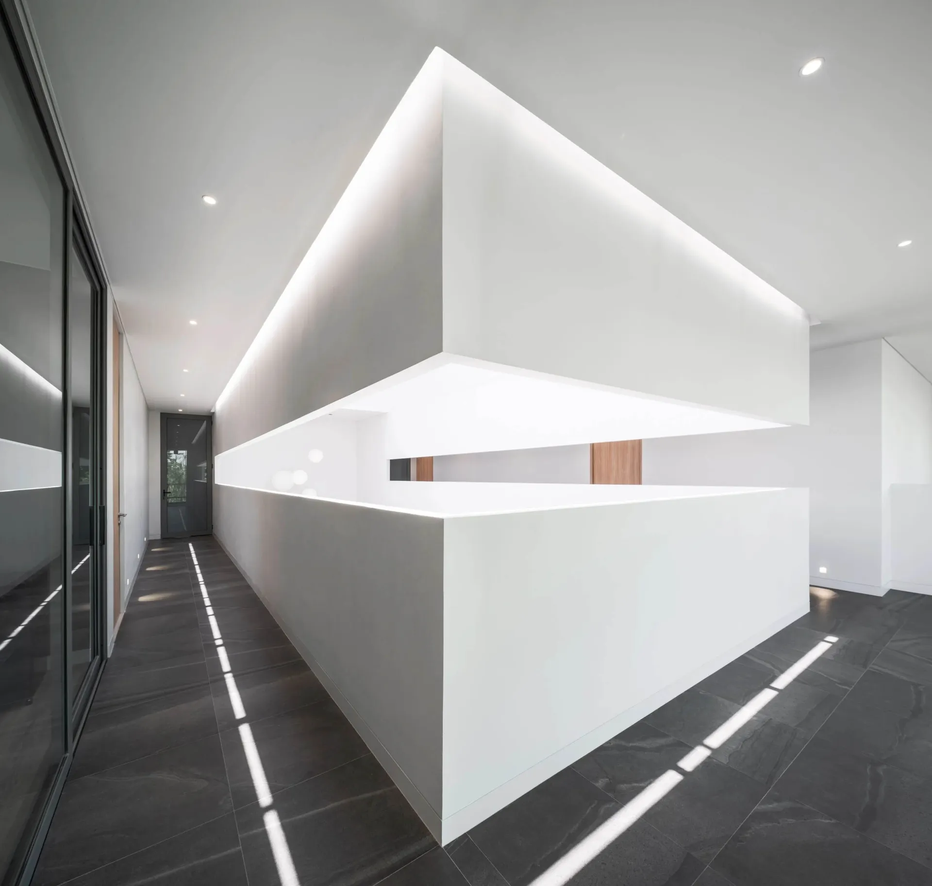 A minimalist office interior featuring concrete walls and flooring.