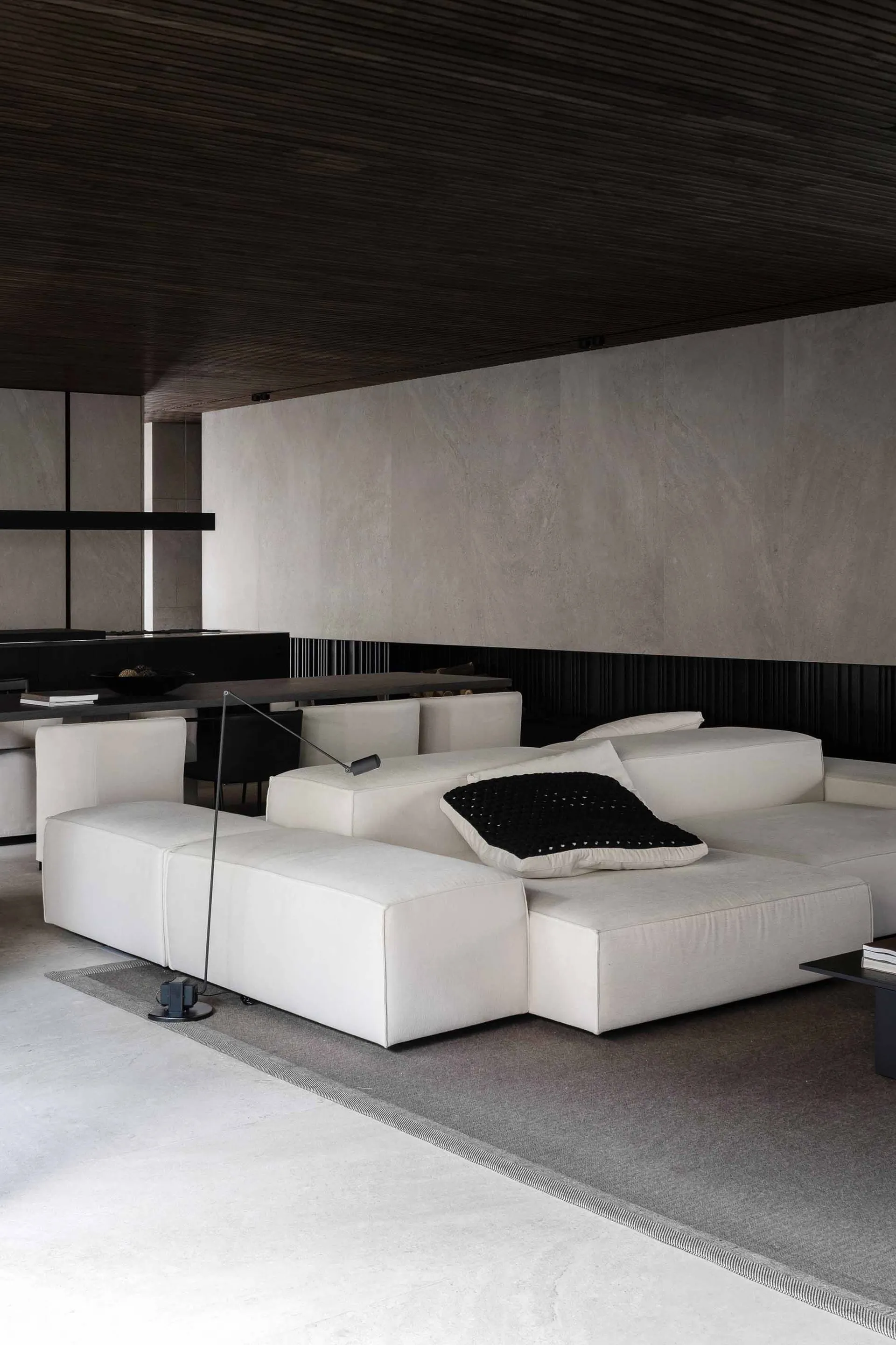 Modern minimalist residential interior with concrete and wooden elements.