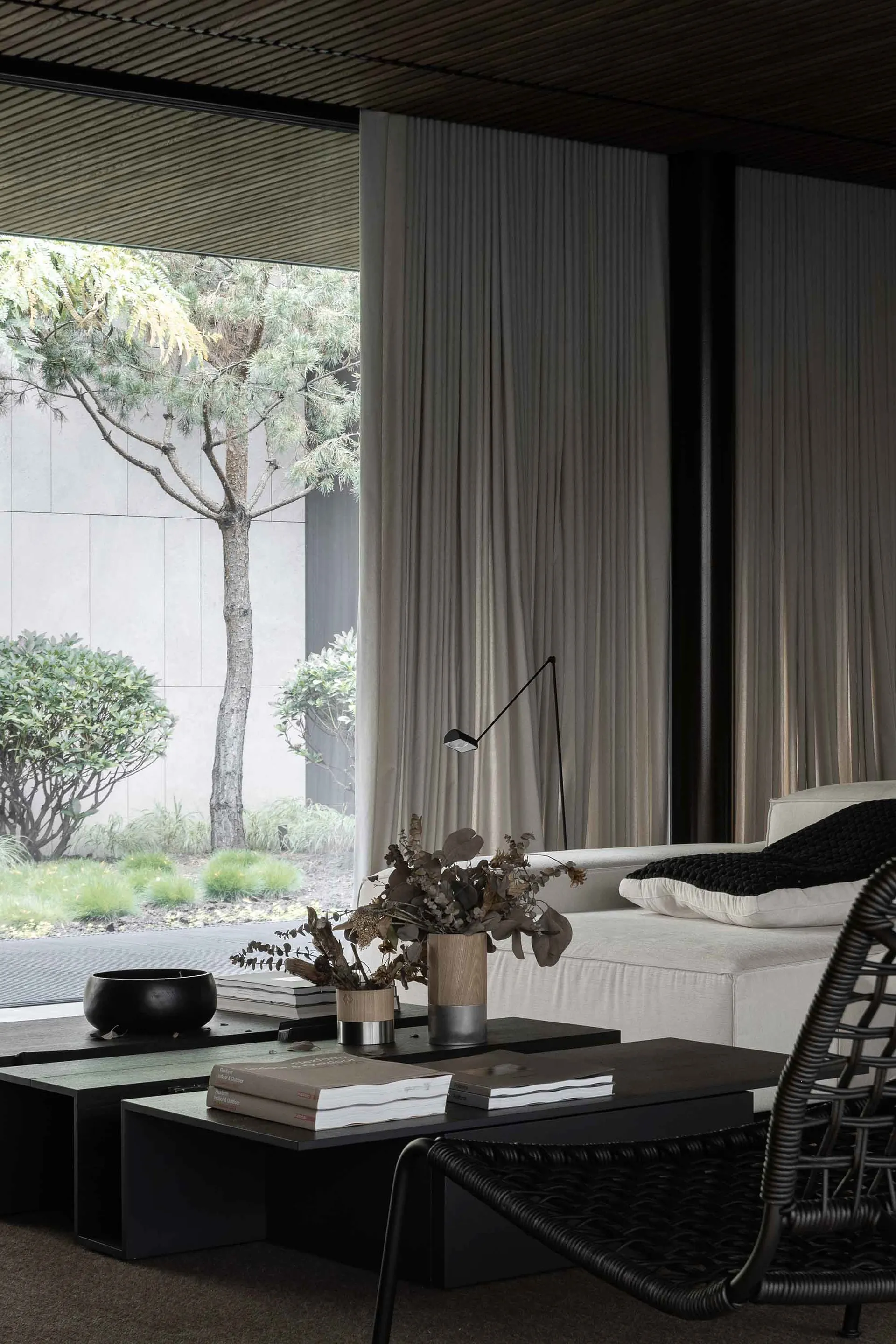 A minimalist living room featuring a white textured sofa adorned with cushions.