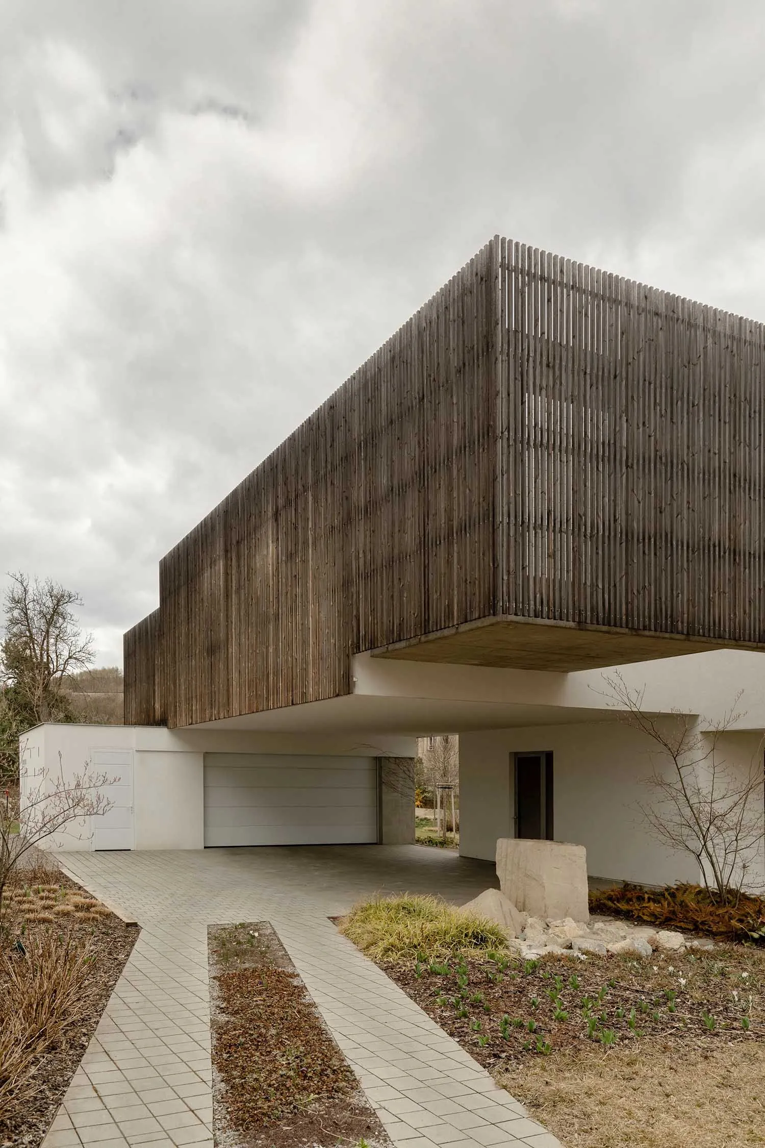 Modern residential building with wood facade and large windows.