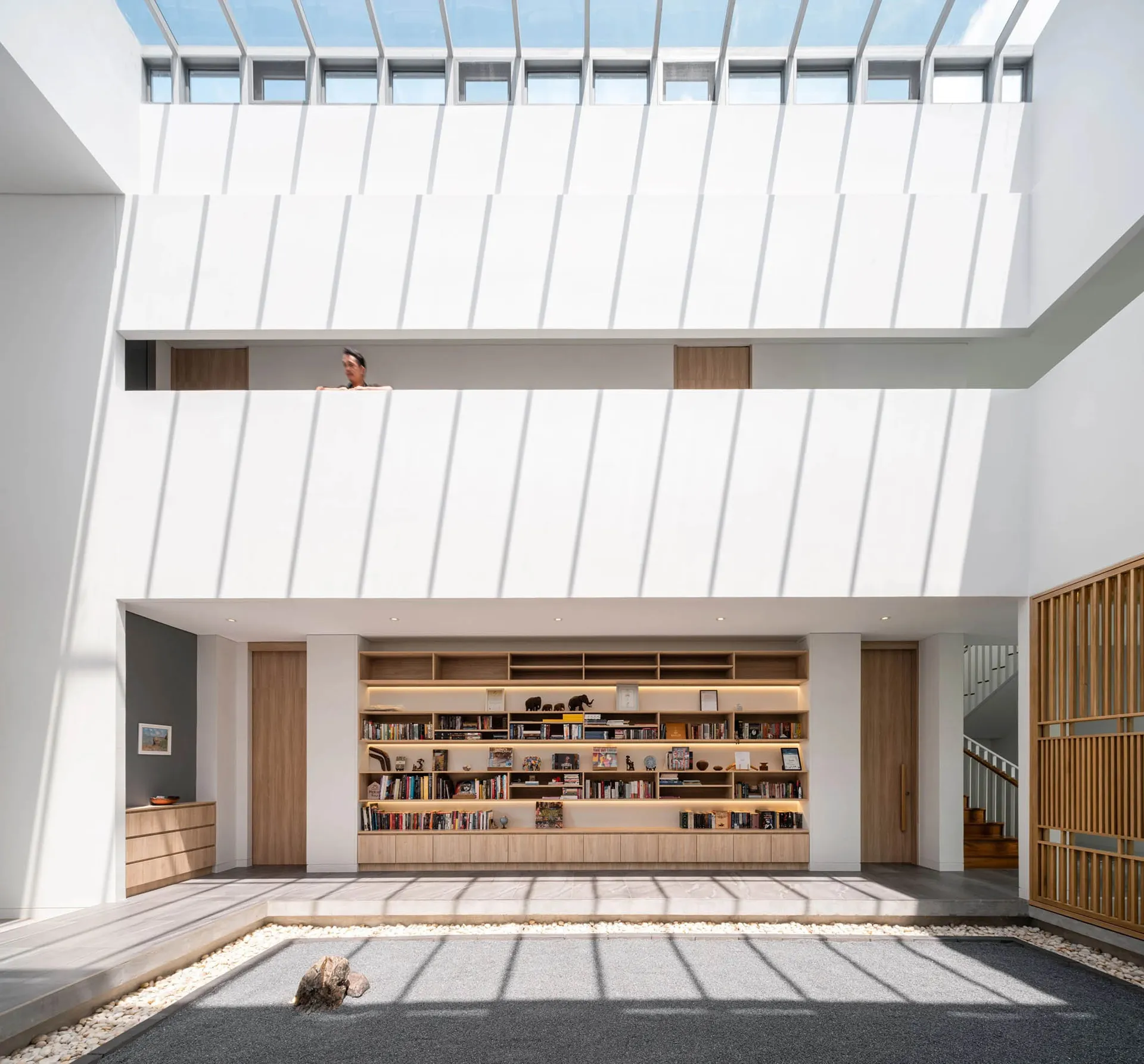 現代極簡客廳,融合混凝土與木質元素,中央設有書架與禪意庭園。