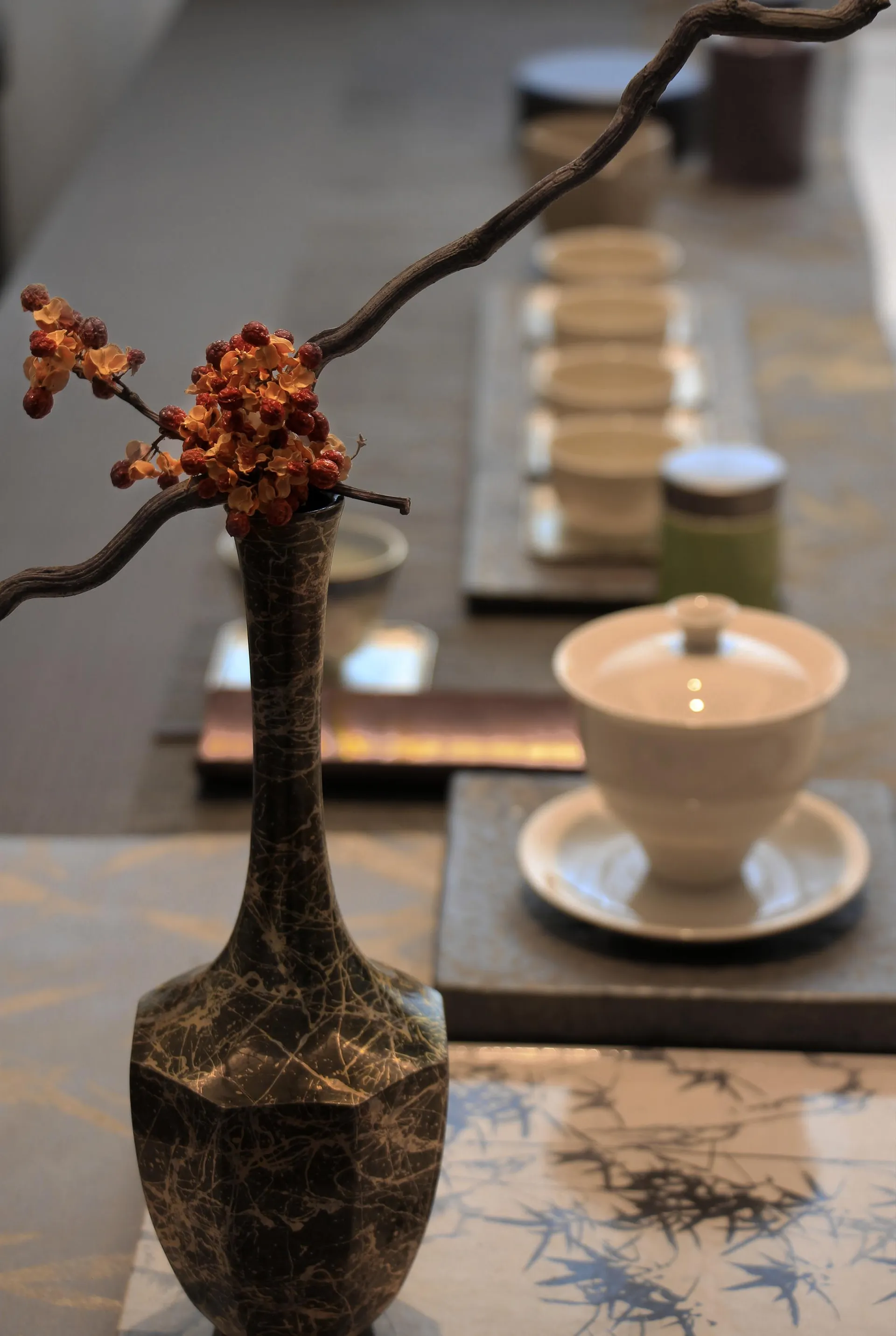 A minimalist interior design featuring ceramic vases and cups, with wooden branches adding a natural touch.