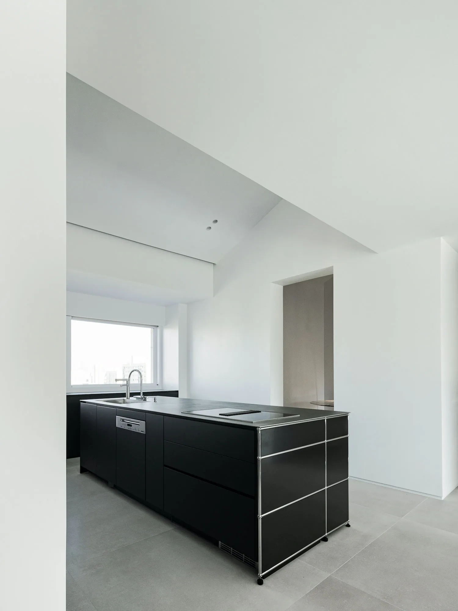 Modern kitchen with black cabinets and concrete countertops.