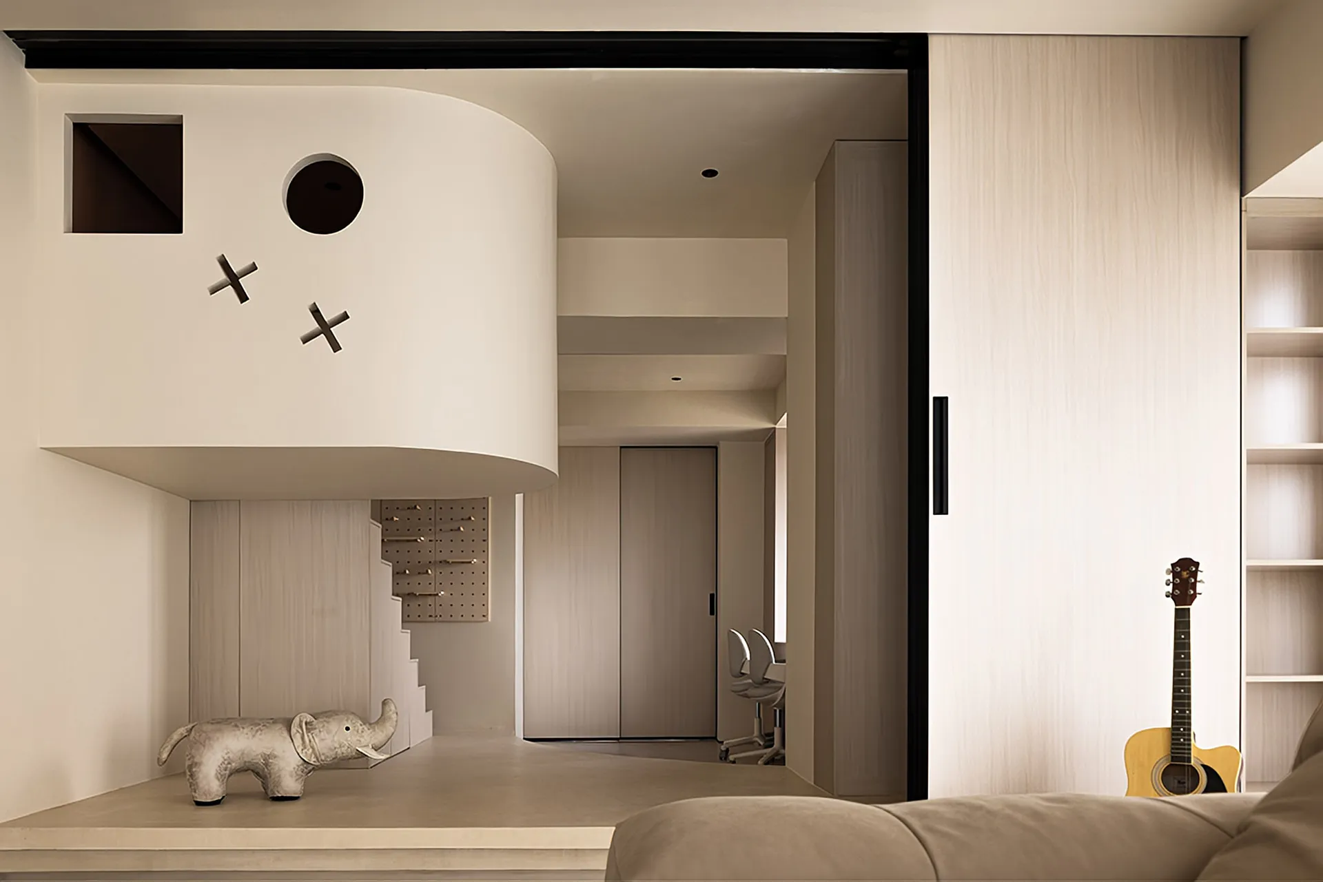 A modern living space featuring a concrete fireplace and staircase with an elephant sculpture and guitar.
