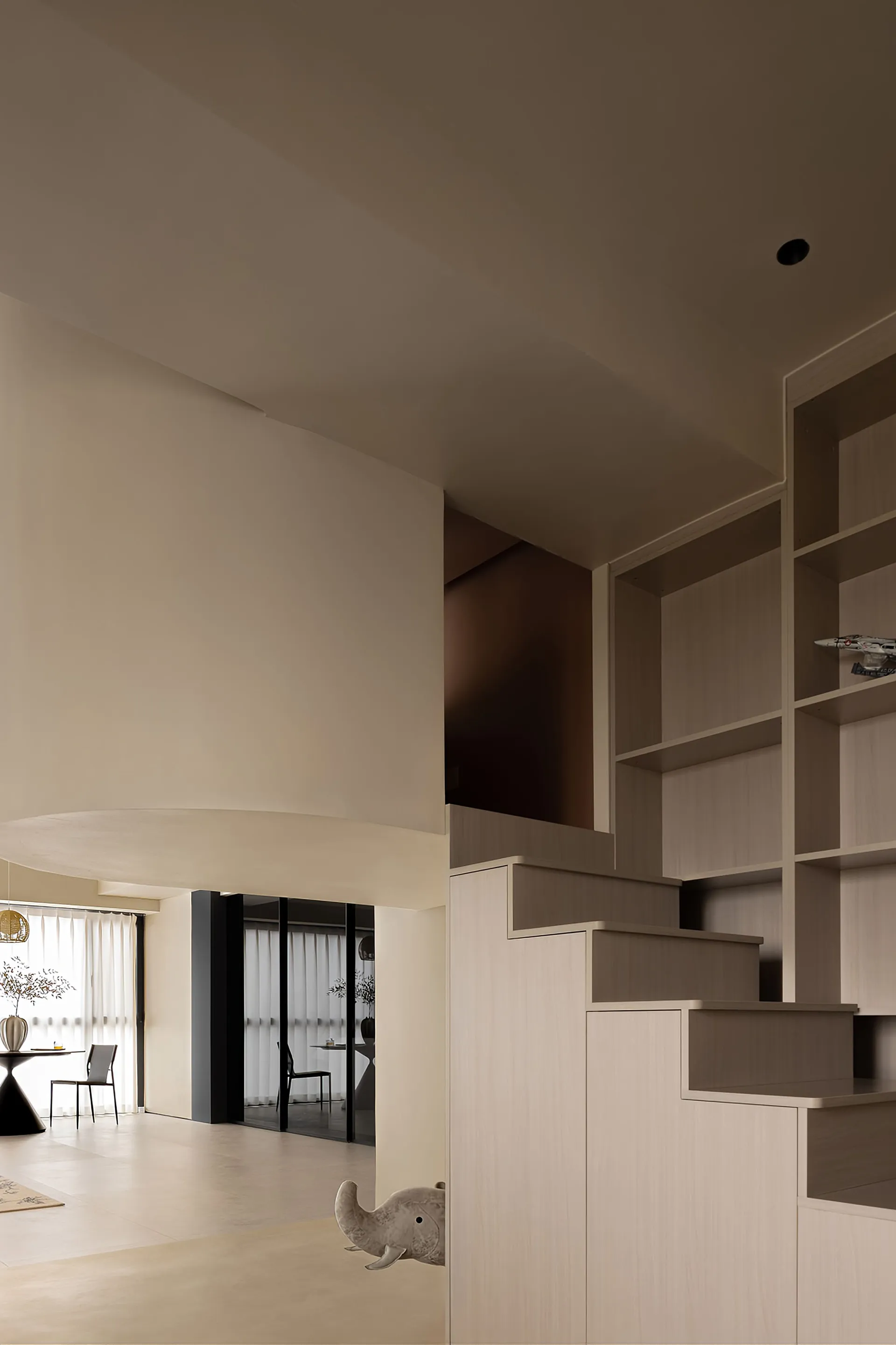 A modern living room with neutral-toned wall paneling, open space, and minimalist decor.