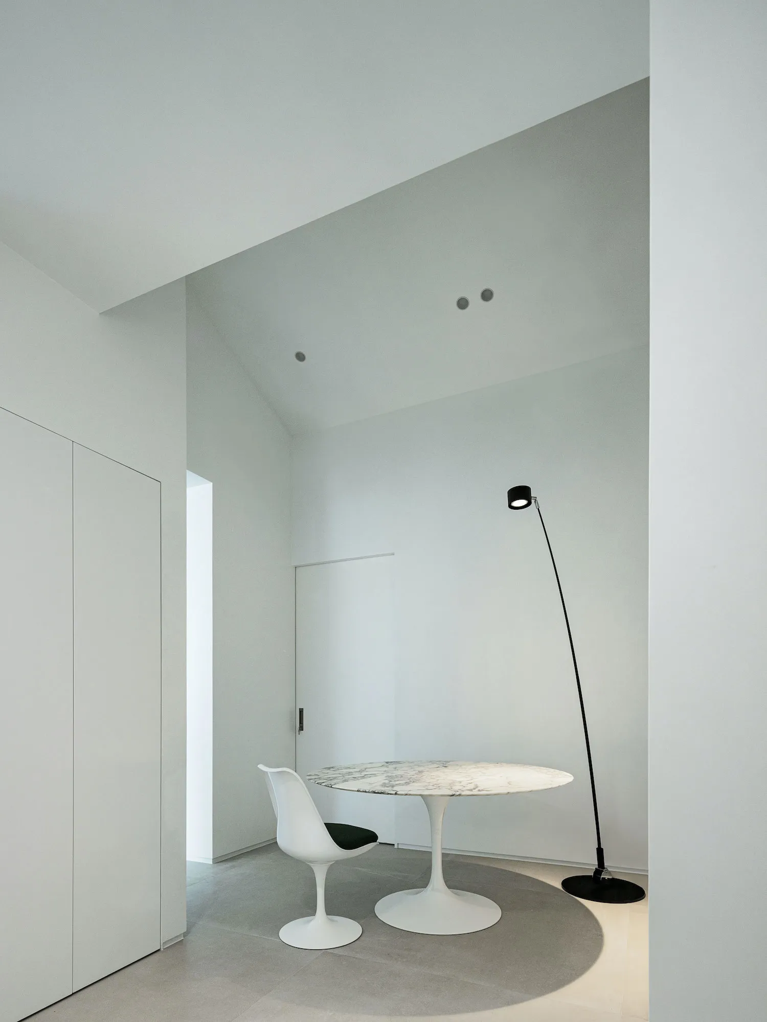 A minimalist study room with a modern marble table and a white chair.