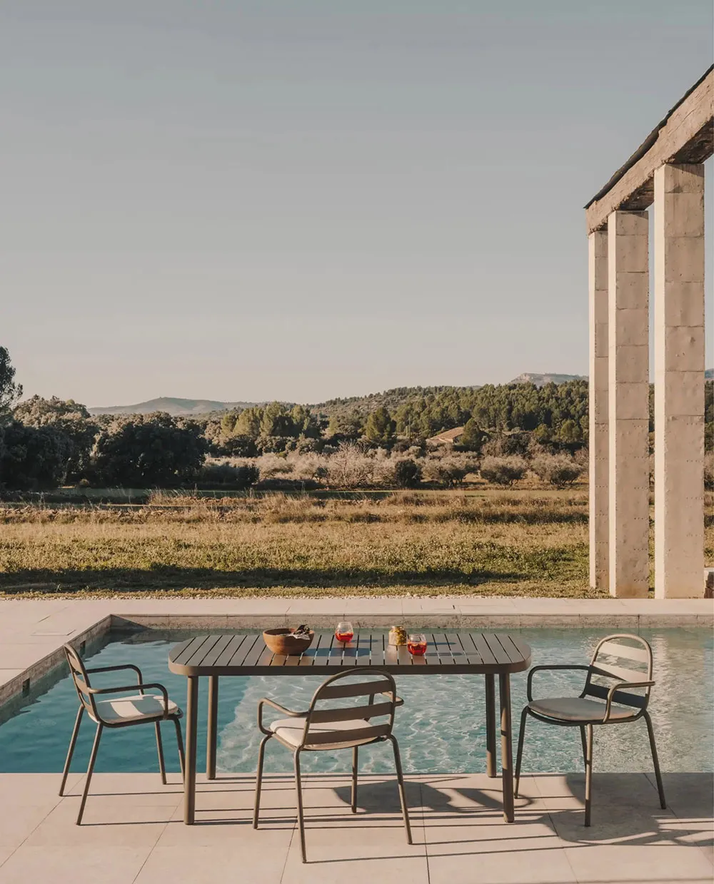 Minimalist outdoor seating area with metallic table and chairs.