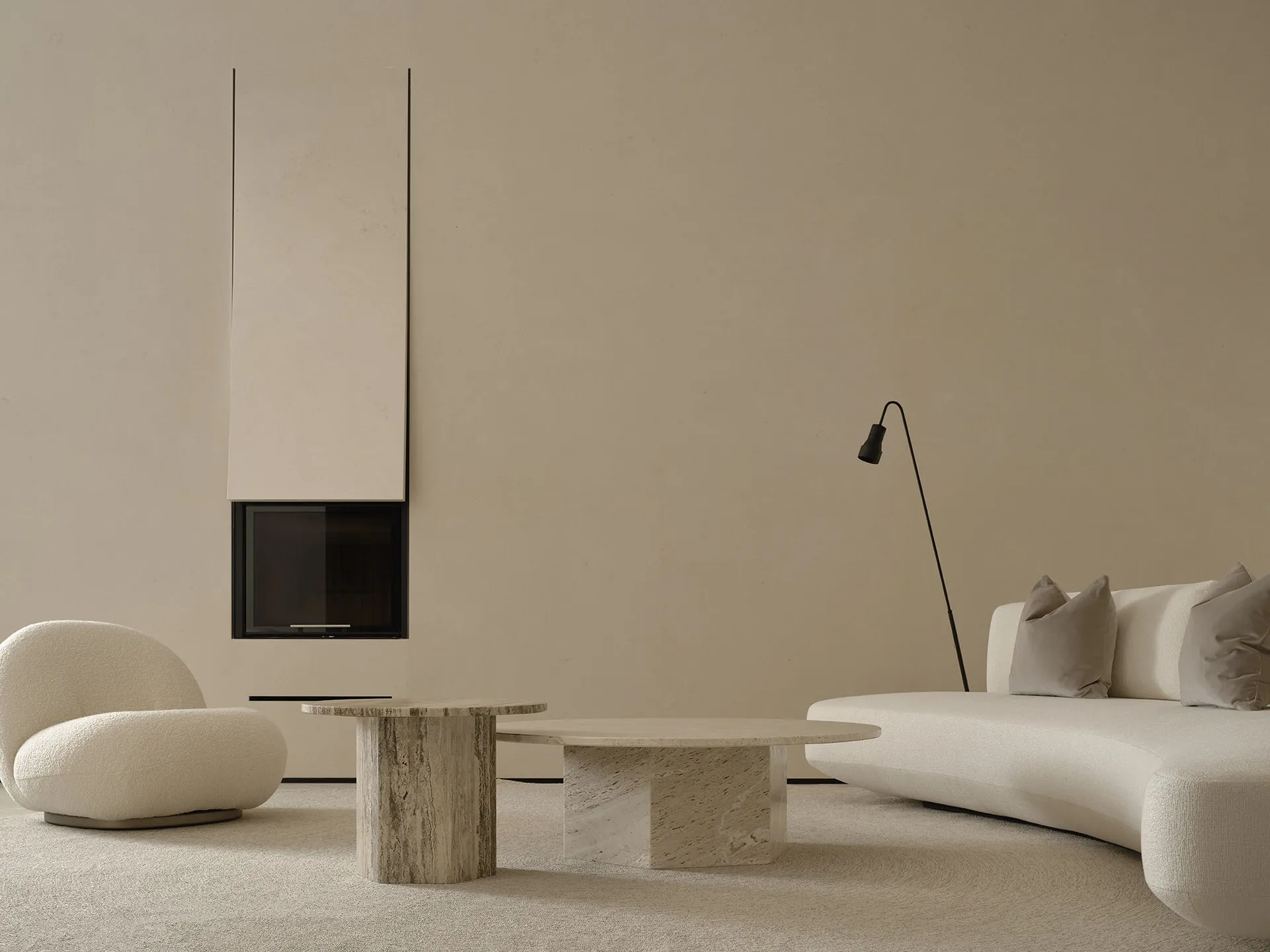 A minimalist living room with stone coffee tables and a curved fabric sofa, accentuated with soft lighting.