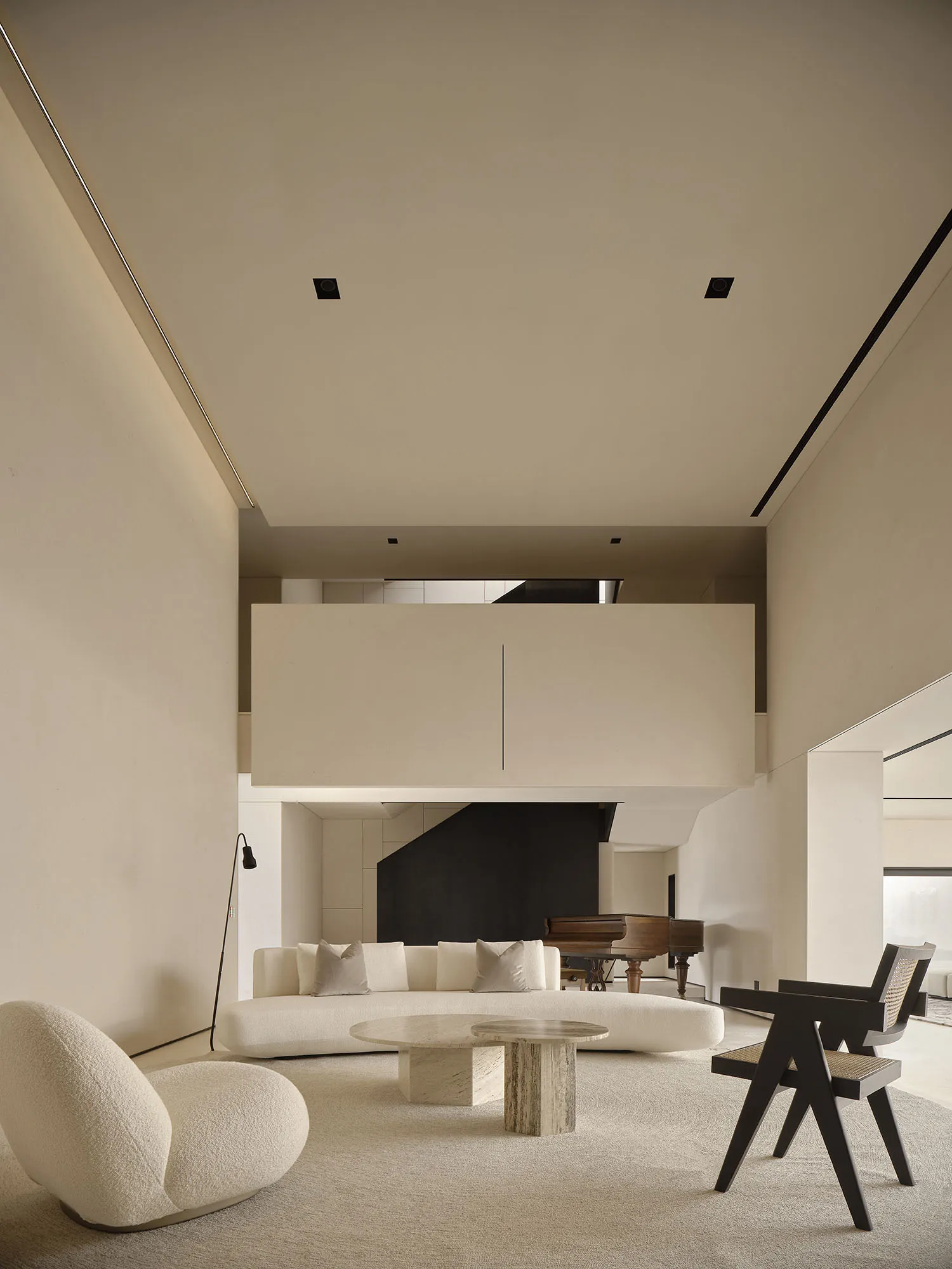 A minimalist living room with a white, textured-cotton sofa and a modern, sleek coffee table.