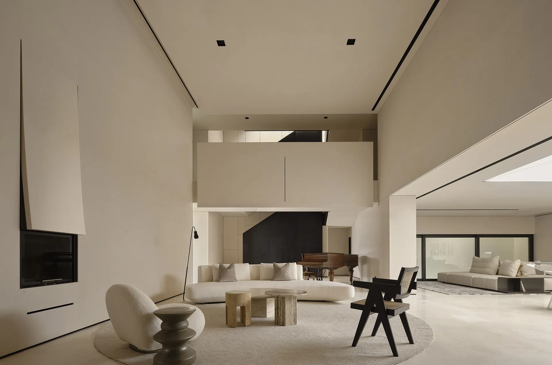 Modern minimalist living room with neutral tones, featuring a white sectional sofa and a grand piano.