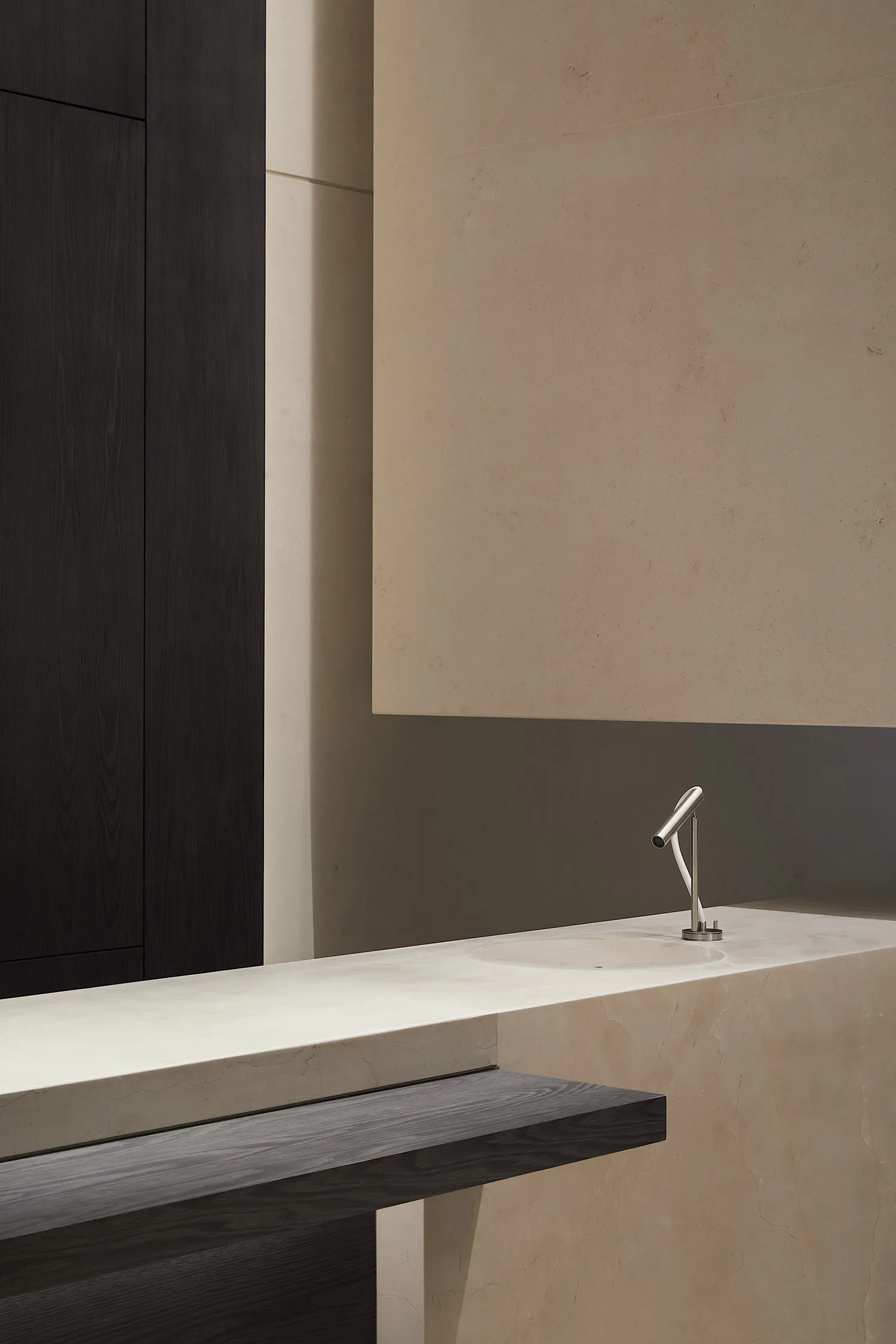 Modern minimalist bathroom featuring a sleek marble counter with a simple faucet.