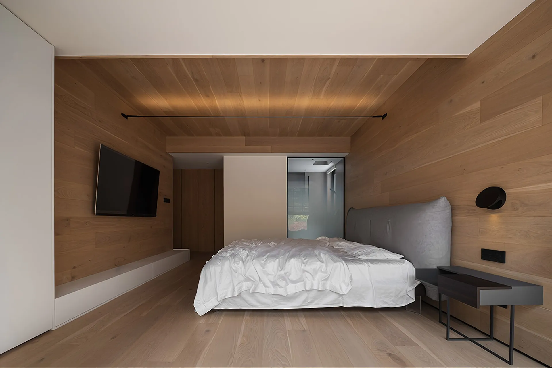 Modern, minimalist bedroom featuring wooden walls, a neatly made bed with white bedding, and a sleek, uncluttered design.