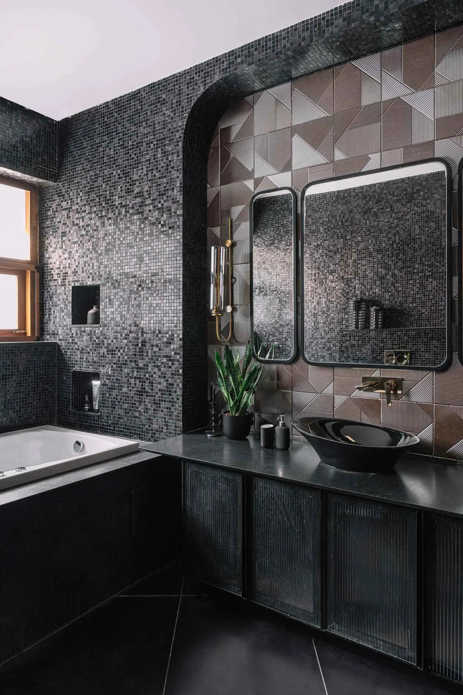 Modern bathroom featuring black mosaic tiles and a sleek, contemporary design.