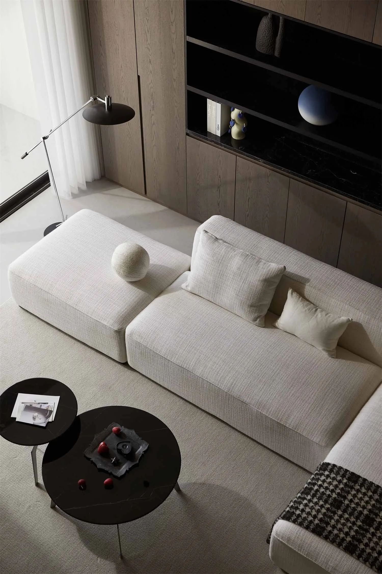 Modern living room featuring fabric couches and marble side tables.