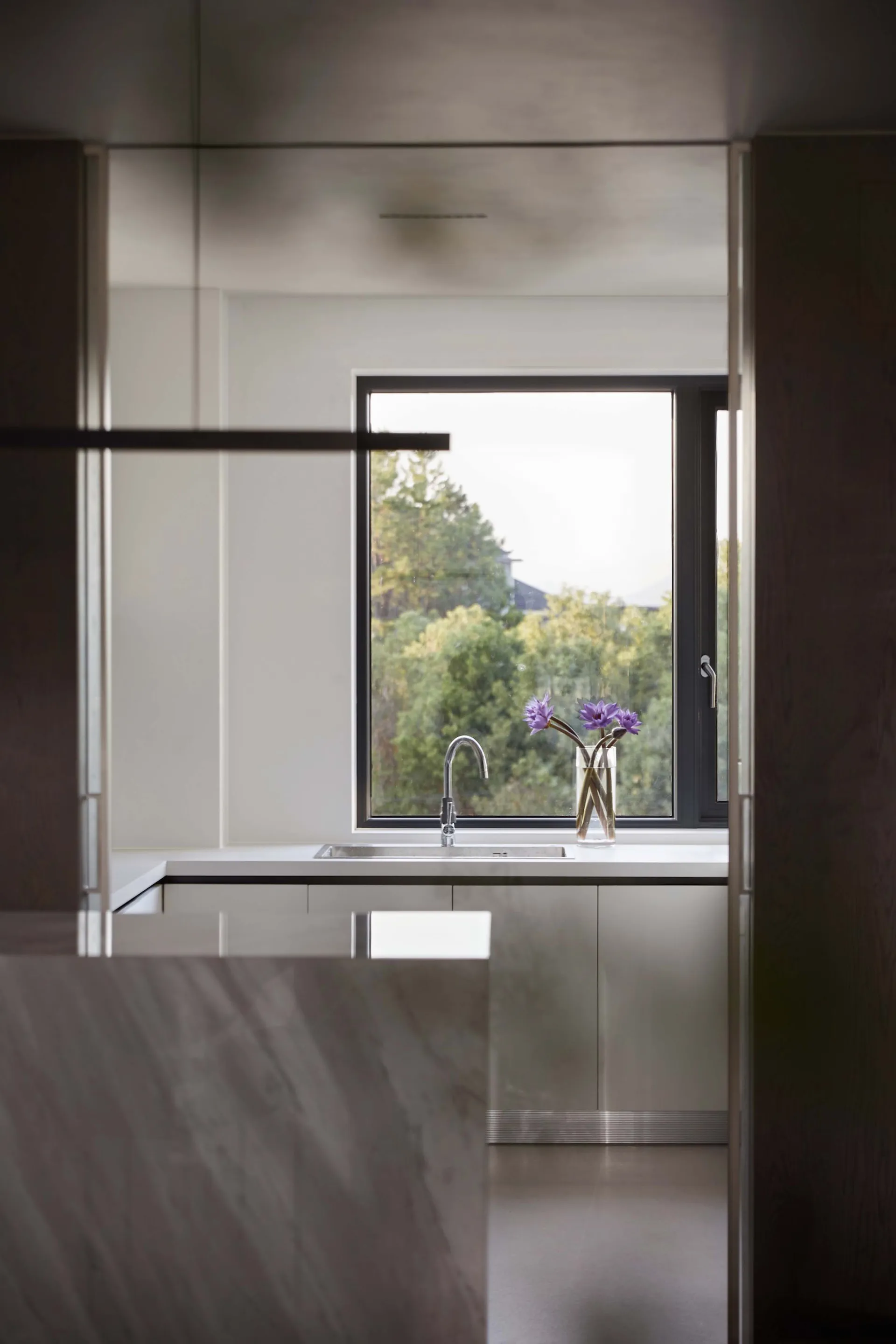 Modern kitchen with marble countertop and window view of nature