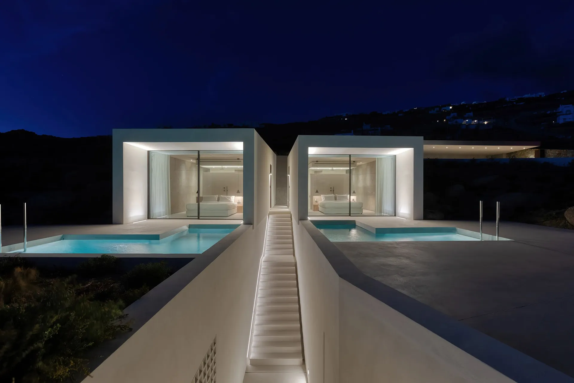 夜晚的現代極簡住宅建築,採用混凝土與玻璃外觀。
