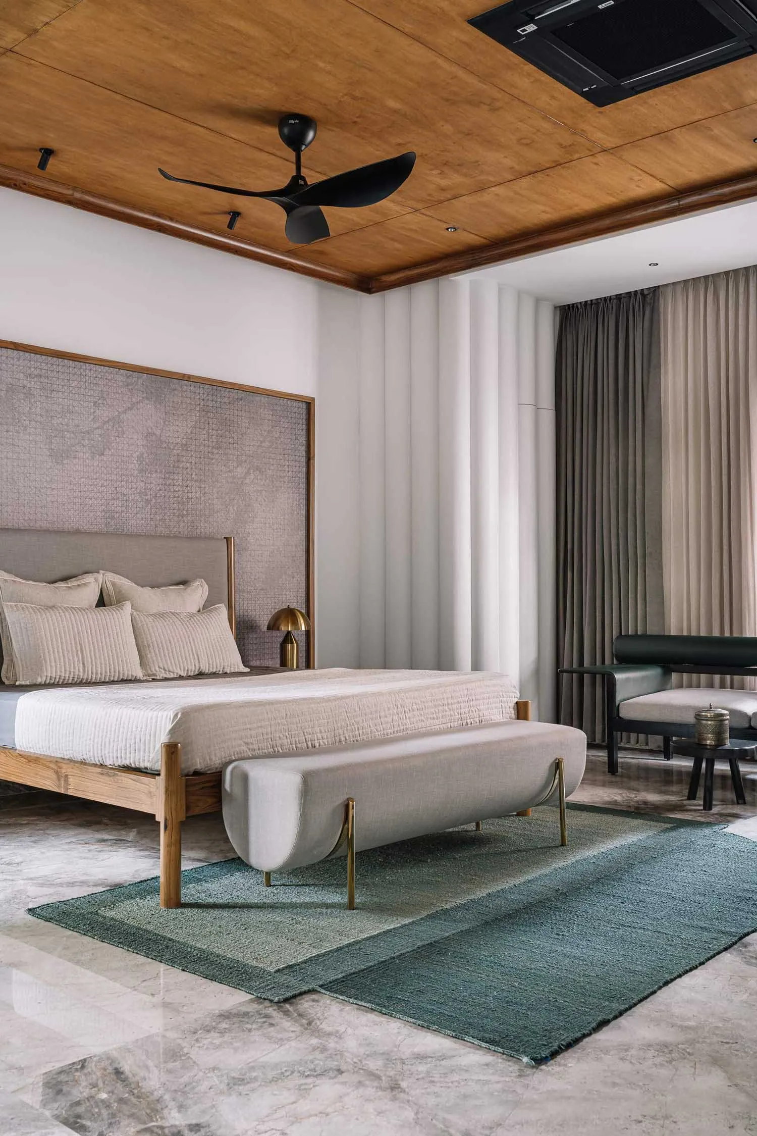 Modern minimalist bedroom featuring a wooden floor, upholstered furniture, and a large window with curtains.