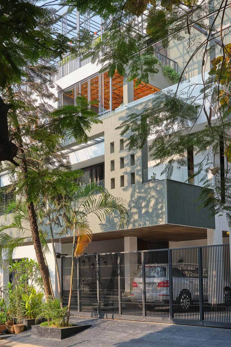 Modern residential building entrance featuring a concrete facade and metal gate.