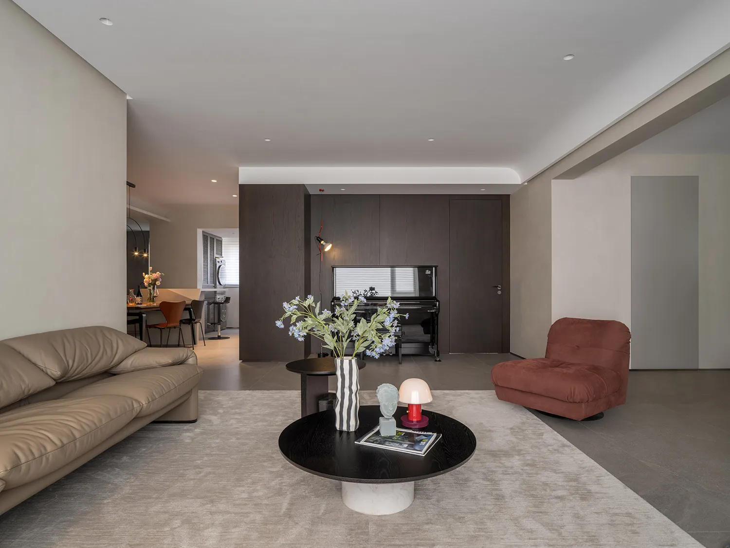 A modern living room with a mix of materials including leather, wood, and glass.