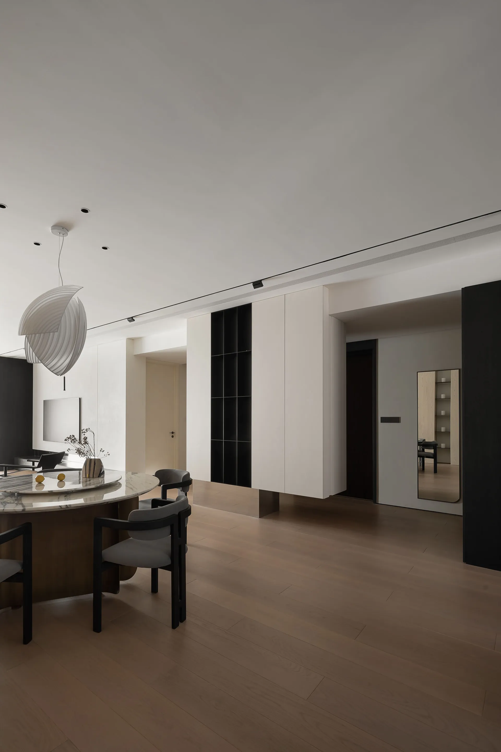 A minimalist indoor space featuring wooden flooring and furniture