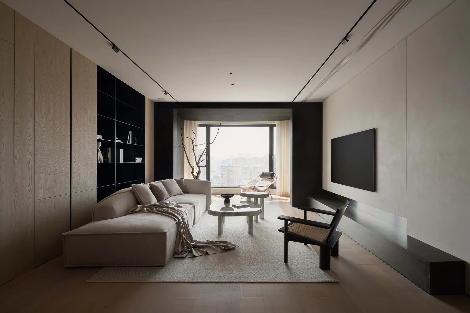 A minimalist living room with wooden paneling, featuring a sofa, coffee table, and large window with city view.