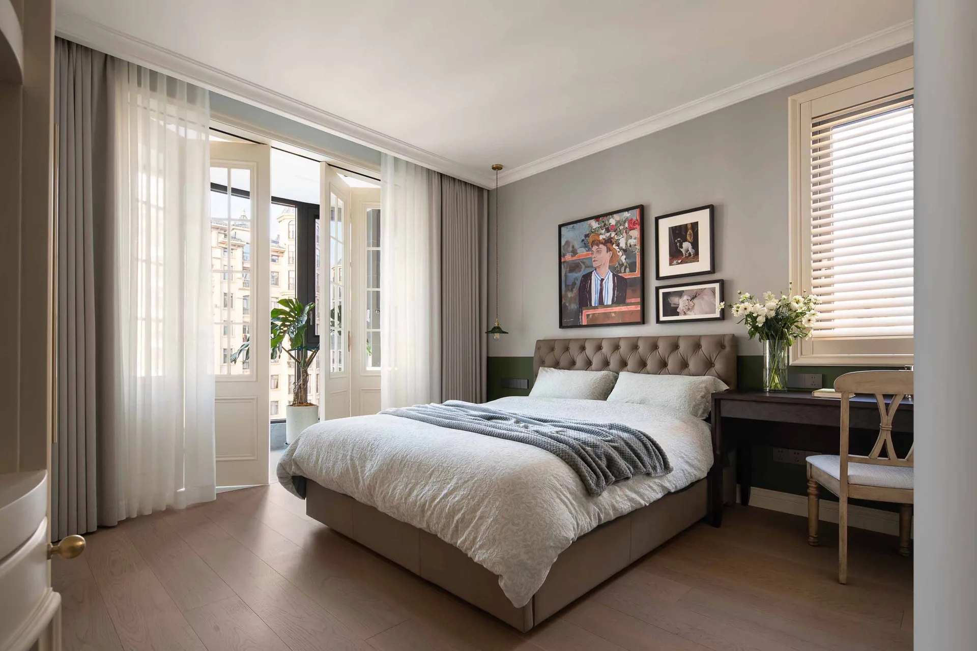 A minimalist bedroom featuring a comfortable bed, elegant furniture, and artistic wall decor, bathed in soft, natural light.