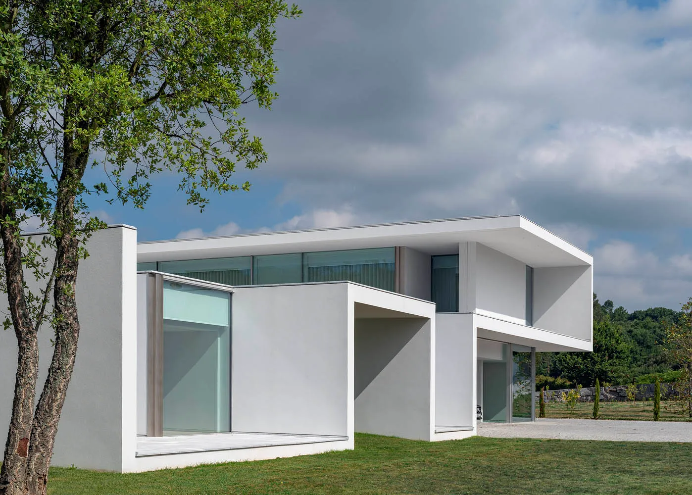 Modern house exterior with glass walls and concrete structure