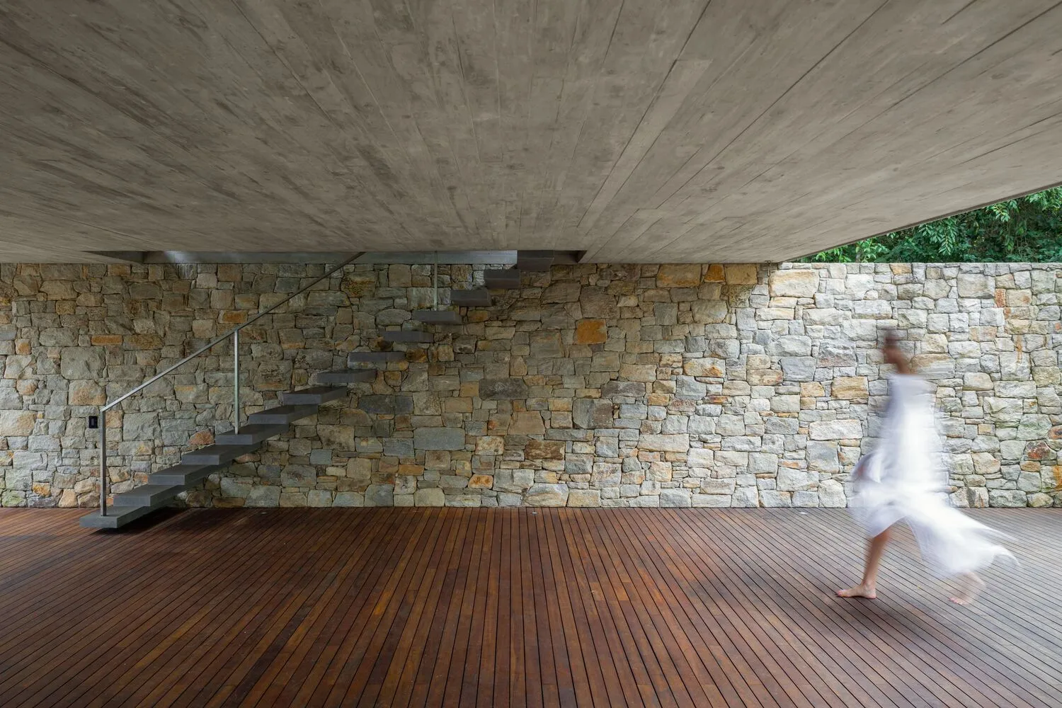 A modern interior space featuring a brick floor and walls, with a concrete ceiling and natural light.