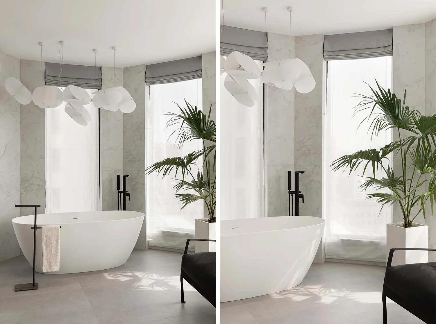 Modern, minimalist bathroom featuring a freestanding white bathtub, large windows, and a hanging cloud-like light fixture.