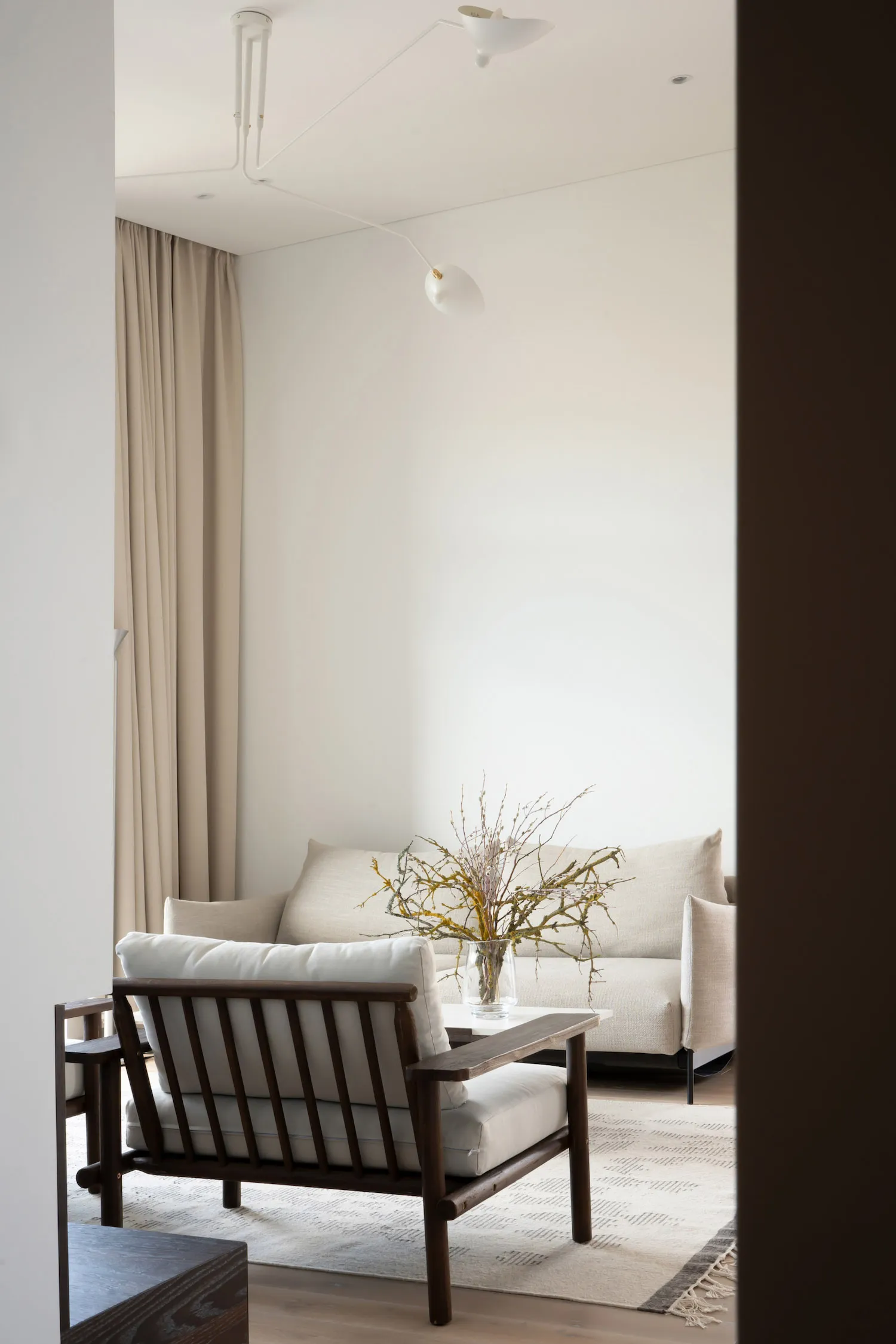 Modern minimalist living room featuring a fabric sofa on a textured rug.