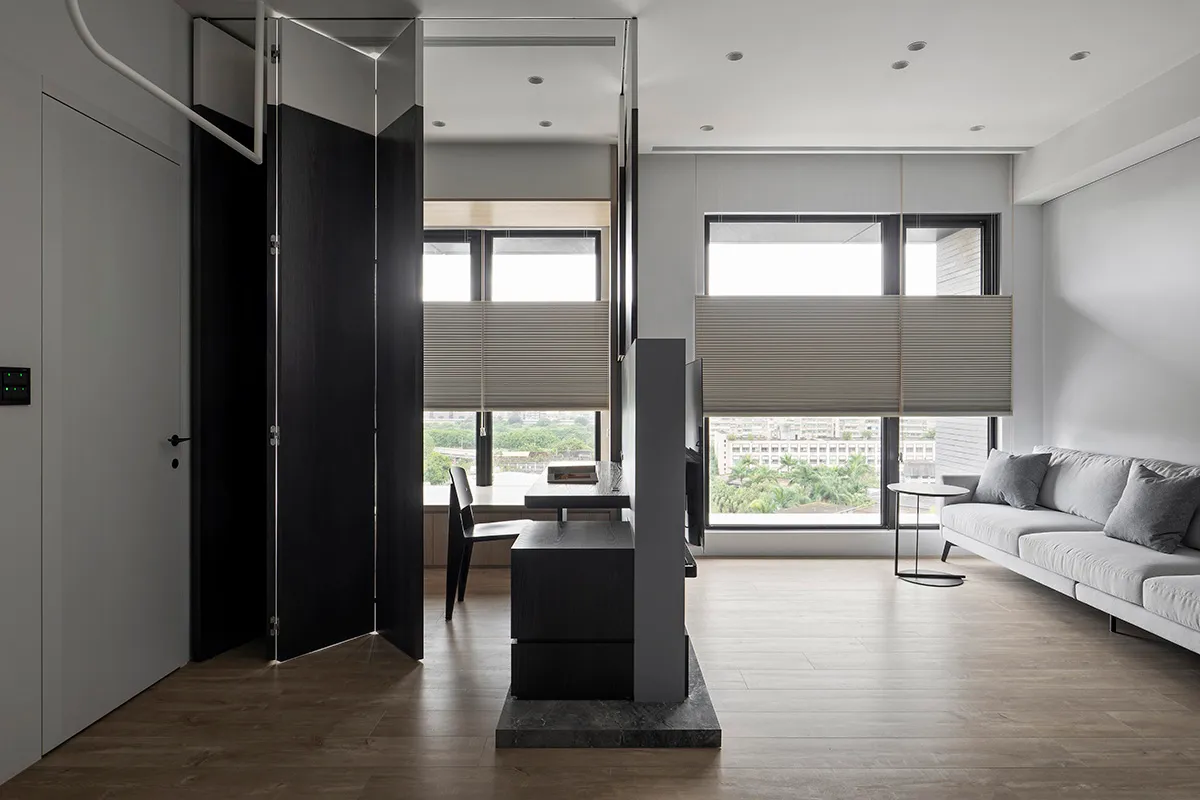 A modern living room featuring glass, wood, and fabric materials with a minimalist design.