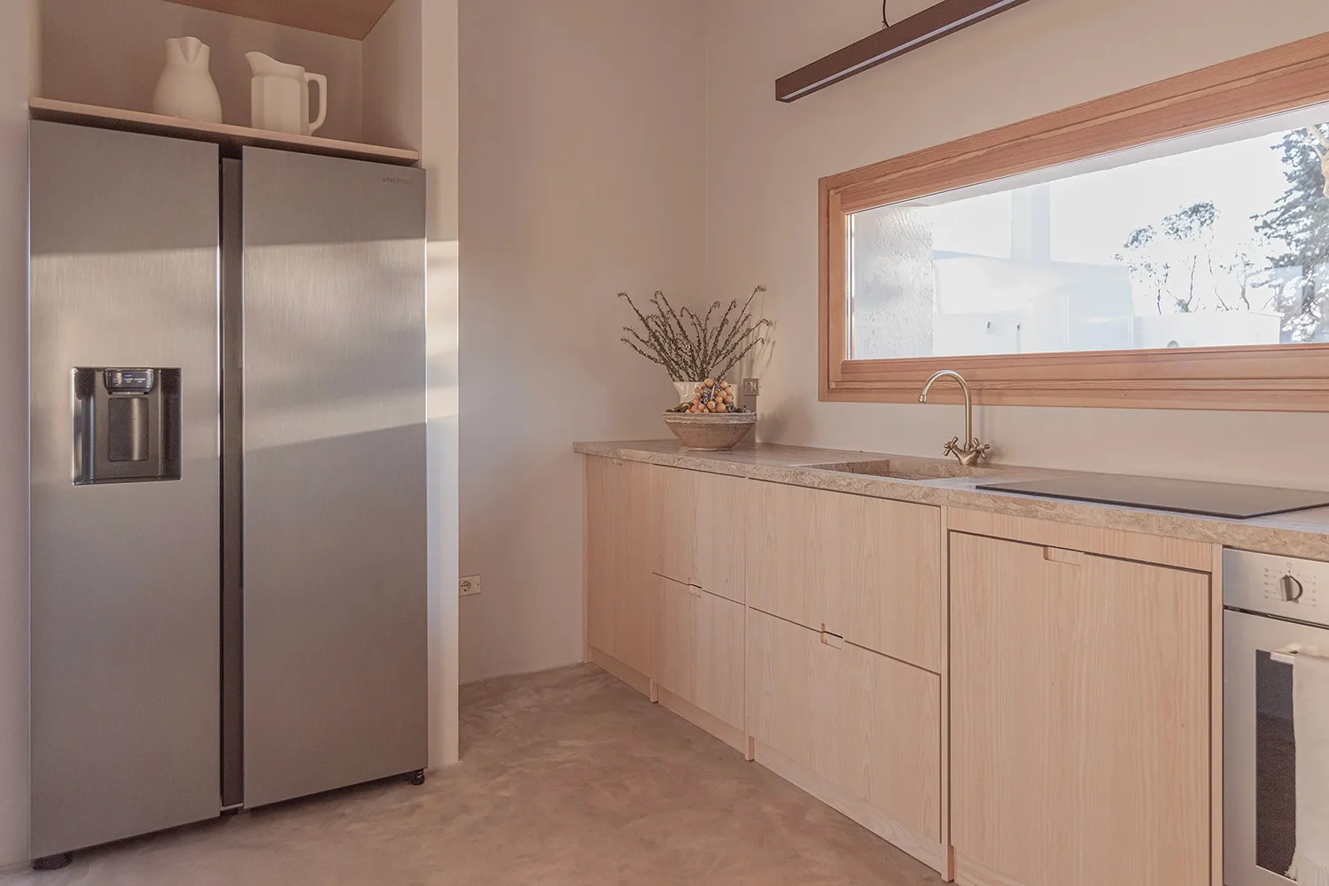 Modern minimalist kitchen featuring sleek glass cabinets and stainless steel appliances.
