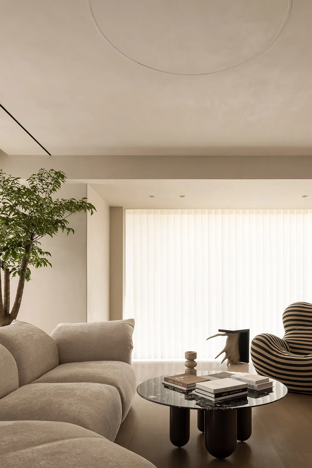 Sofa, chair, and coffee table in a minimalist living room with neutral-colored textiles.