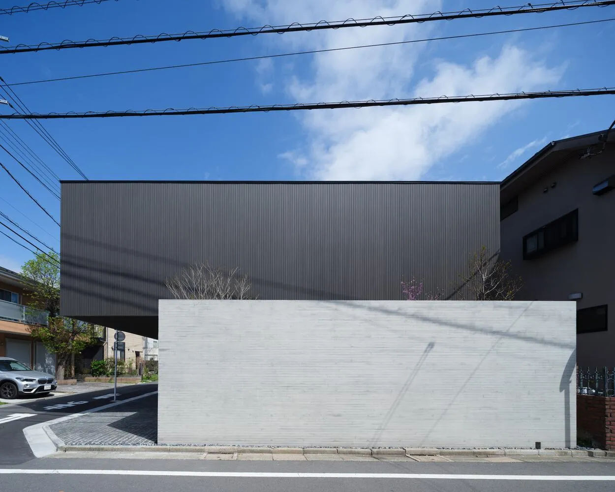 A modern black-box building made of concrete with a minimalist design and a flat roof.