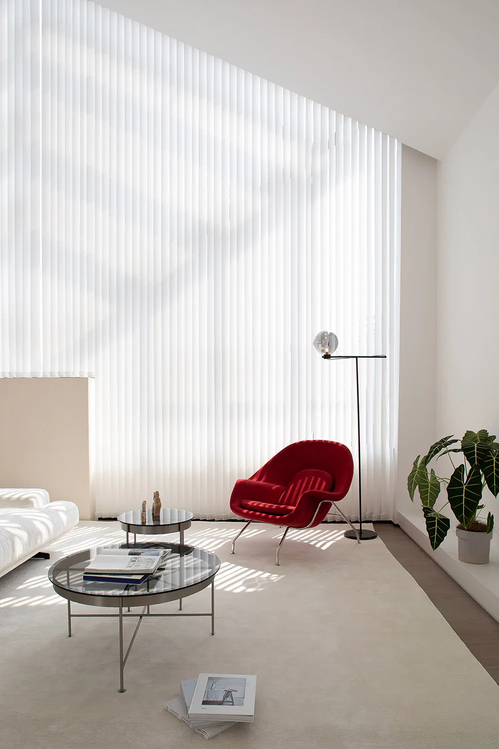 A modern interior design featuring a glass window with vertical blinds.