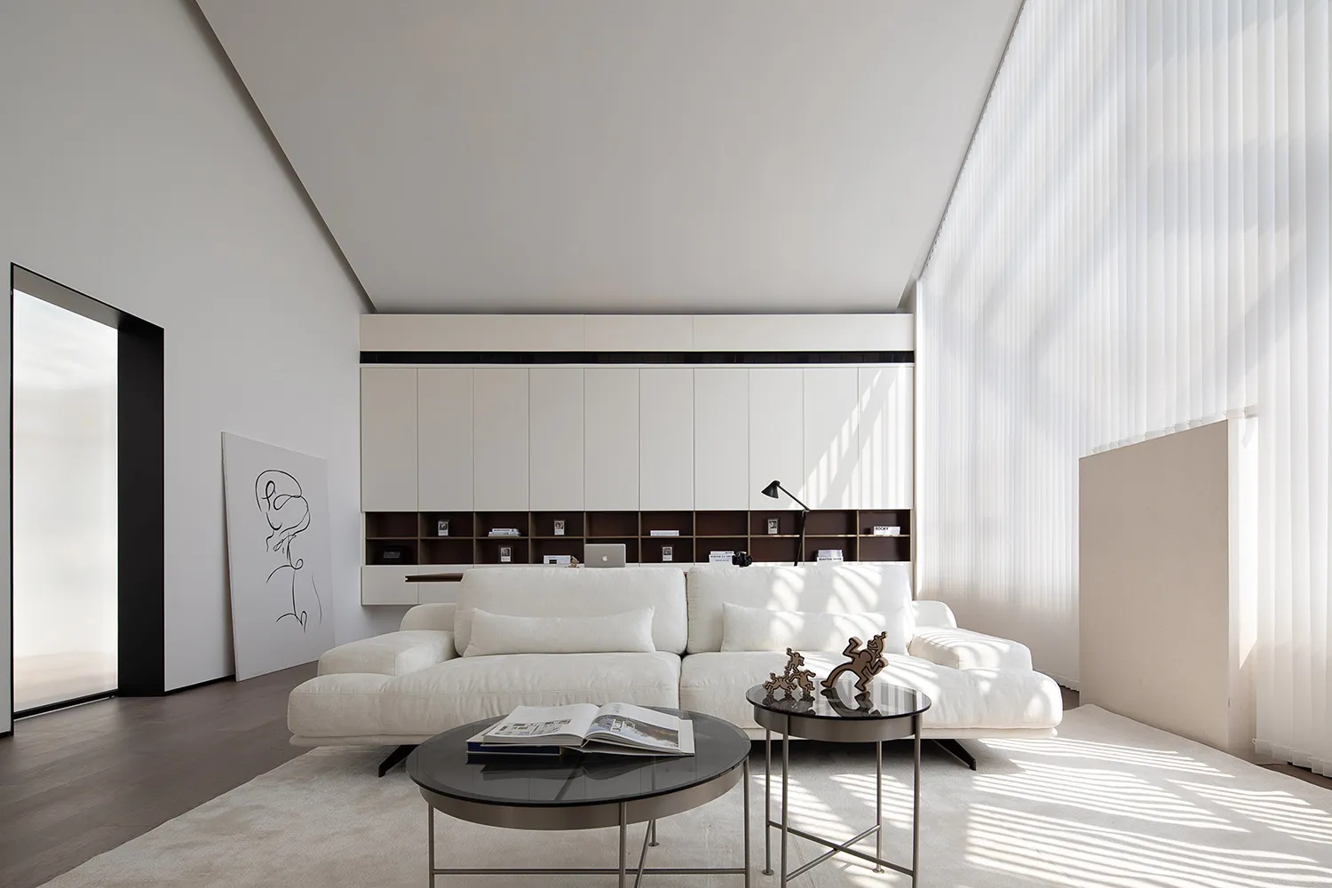 Contemporary living room with white furniture, white walls, and a large window.