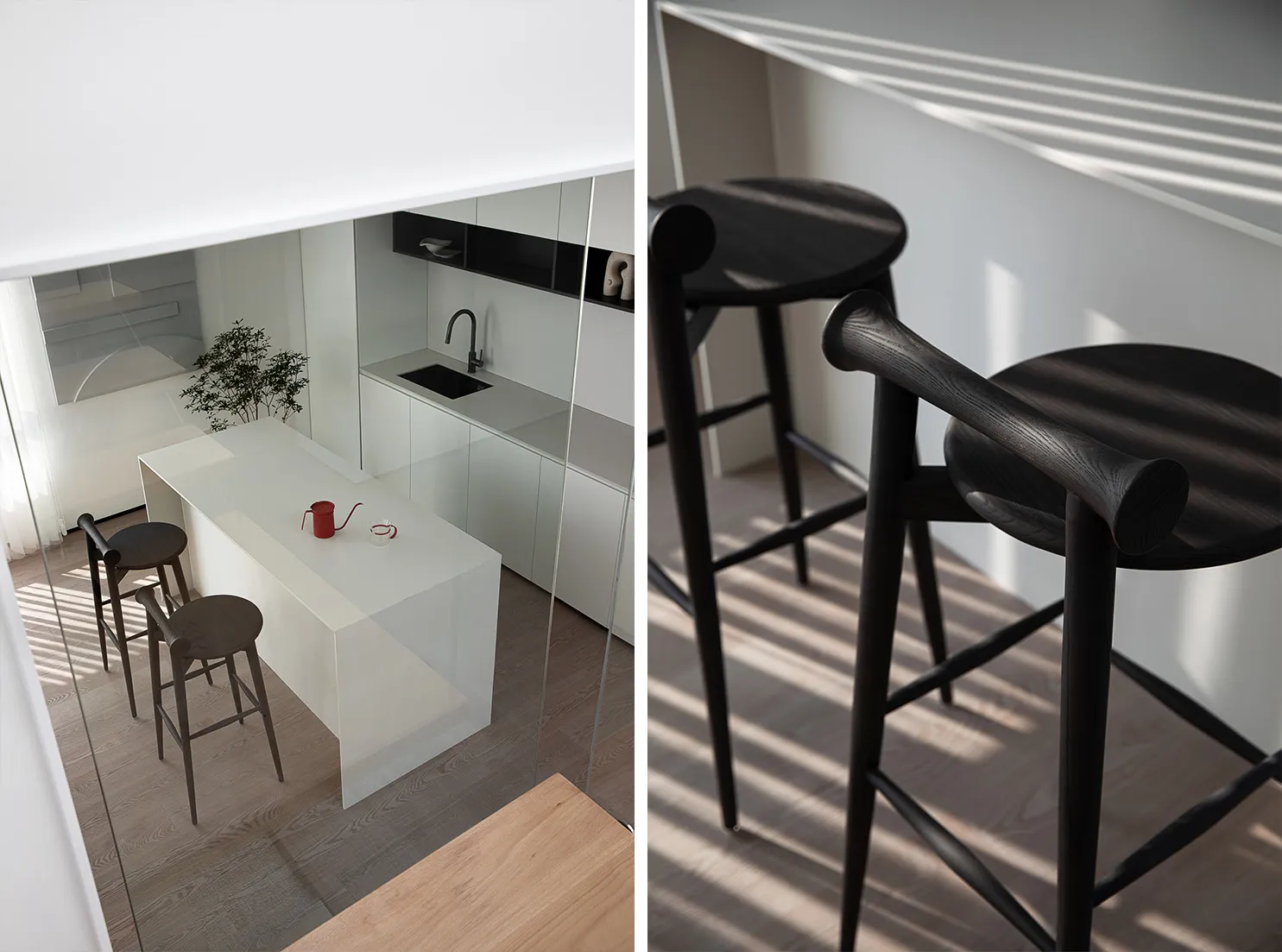 Modern kitchen featuring white marble countertops and black wood stools