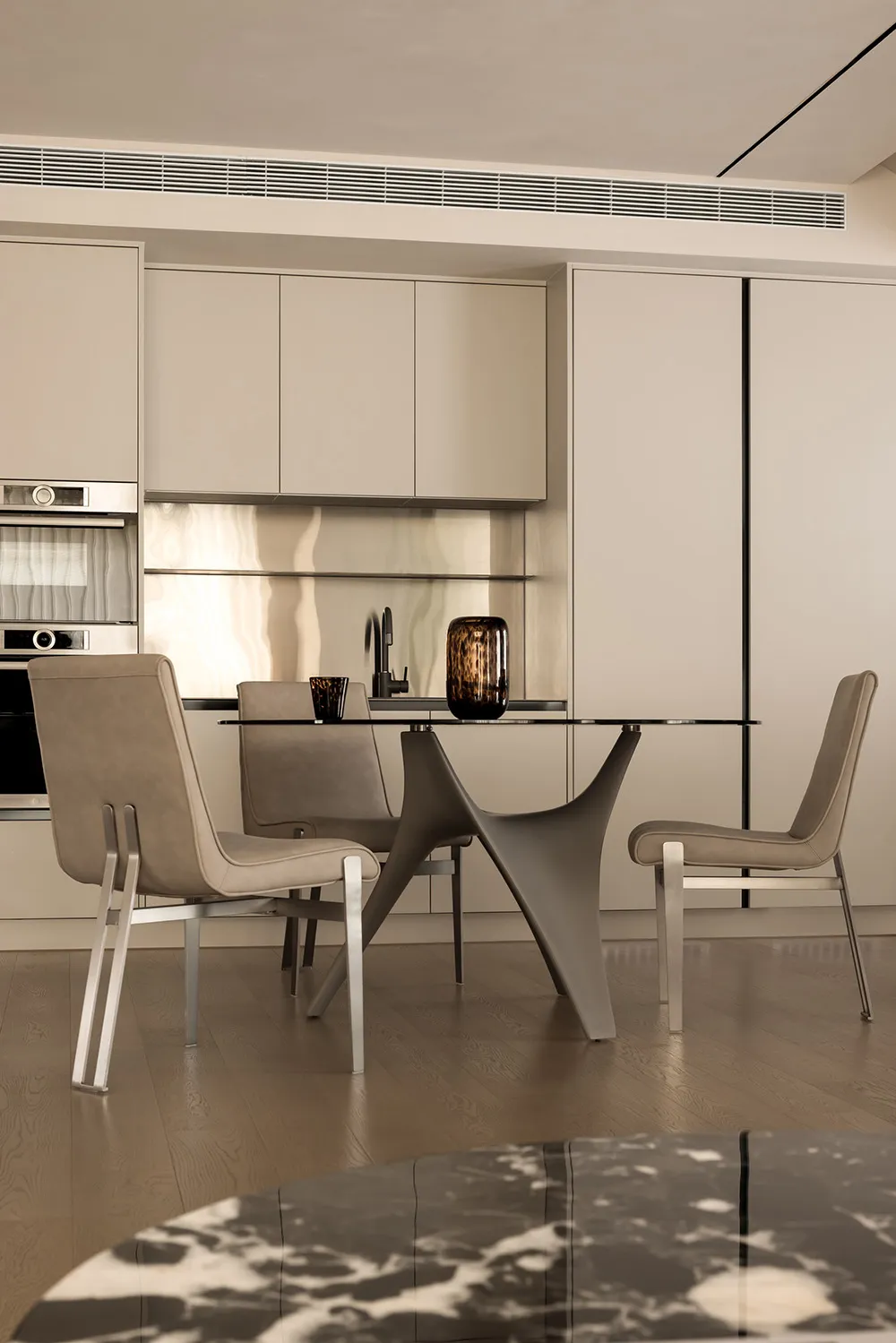 A modern, neutral-colored kitchen with a glass dining table and minimalist design.