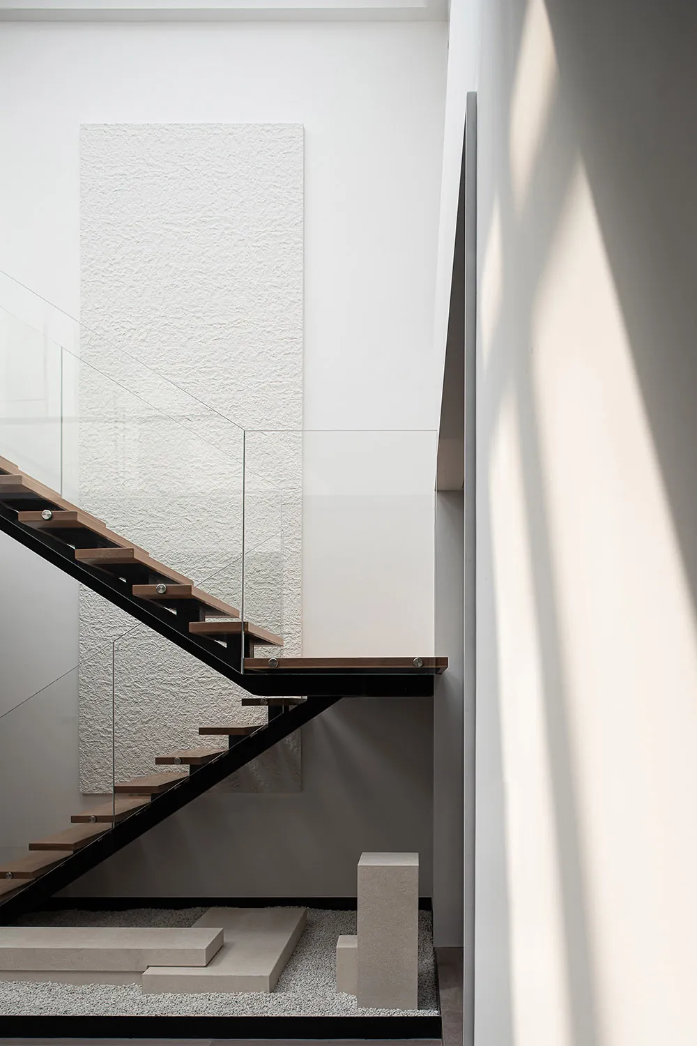 A modern staircase with black metal rails and wooden steps.