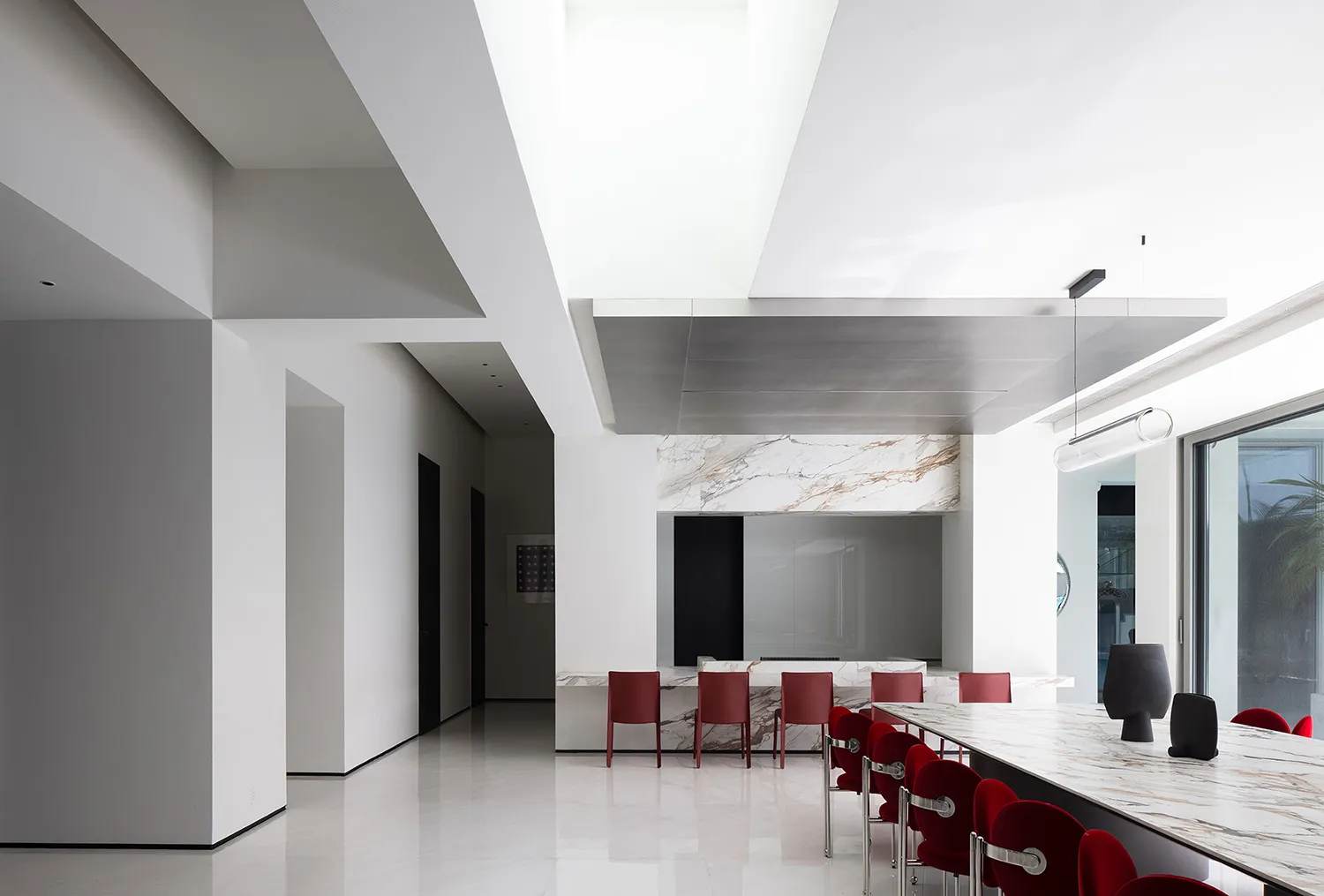 A modern interior design featuring a marble bar counter with red chairs and a white marble floor.
