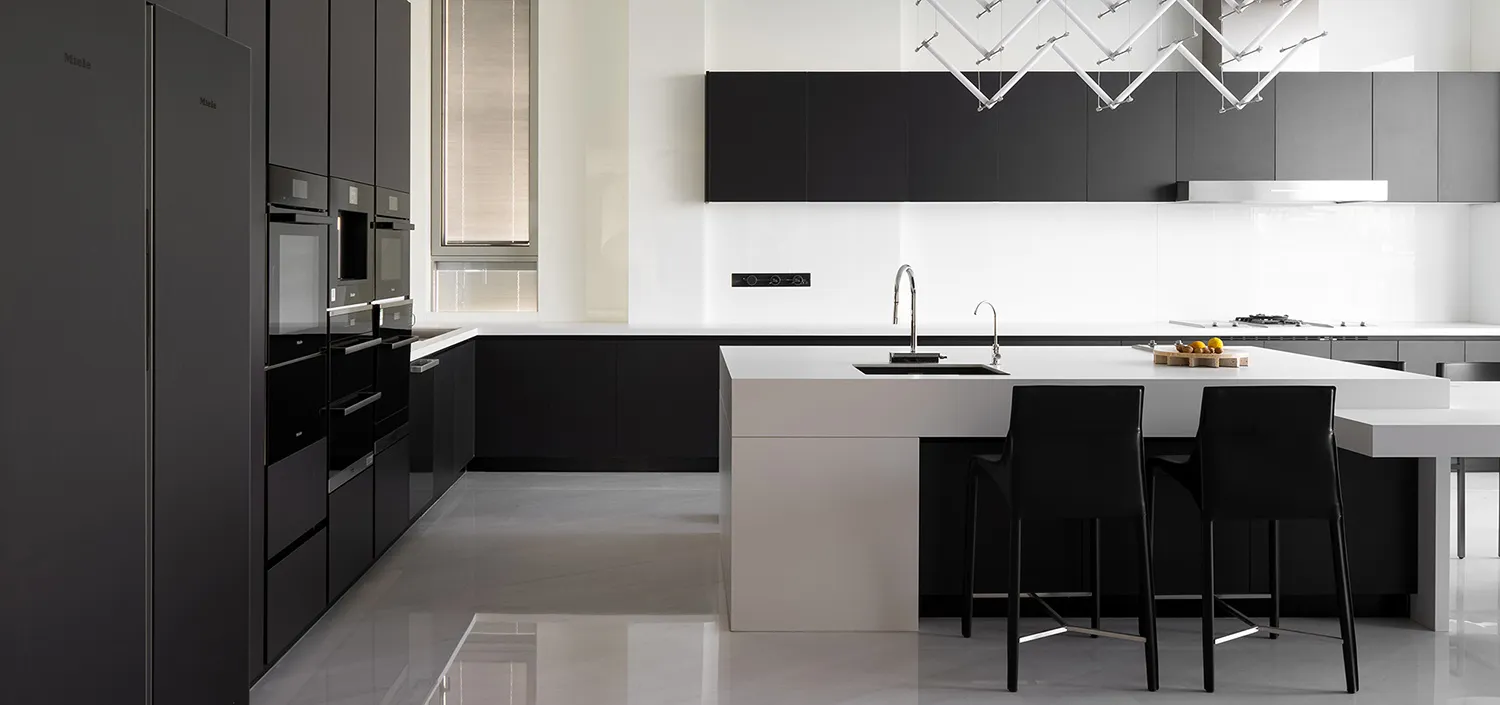Modern black kitchen featuring a sleek white countertop and minimalist design elements.