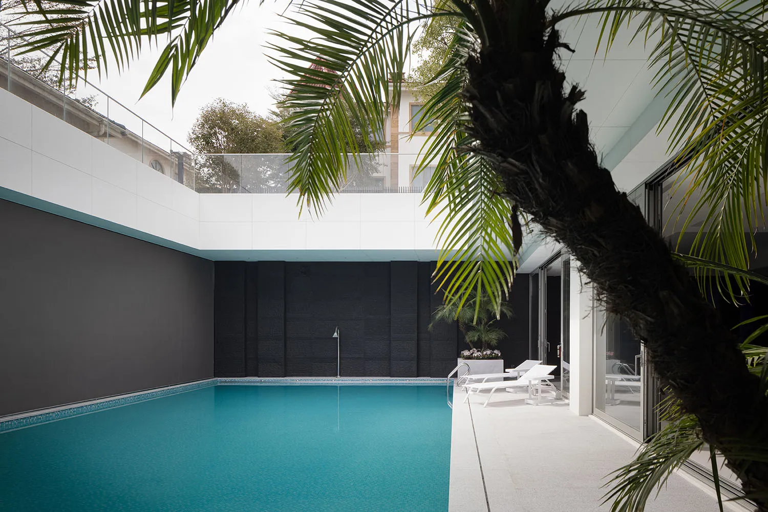 Modern residential exterior featuring metal, glass, and concrete materials.