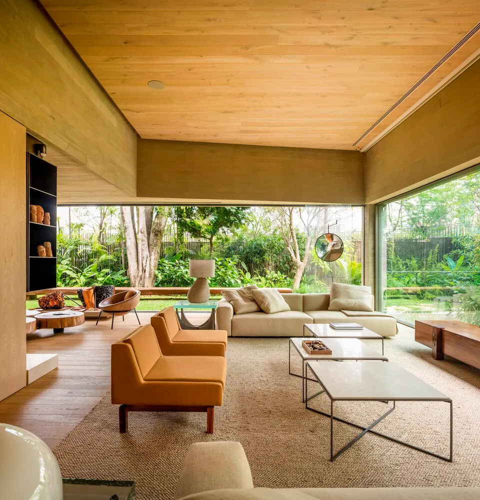 A modern interior design featuring a living room with wood and glass elements.