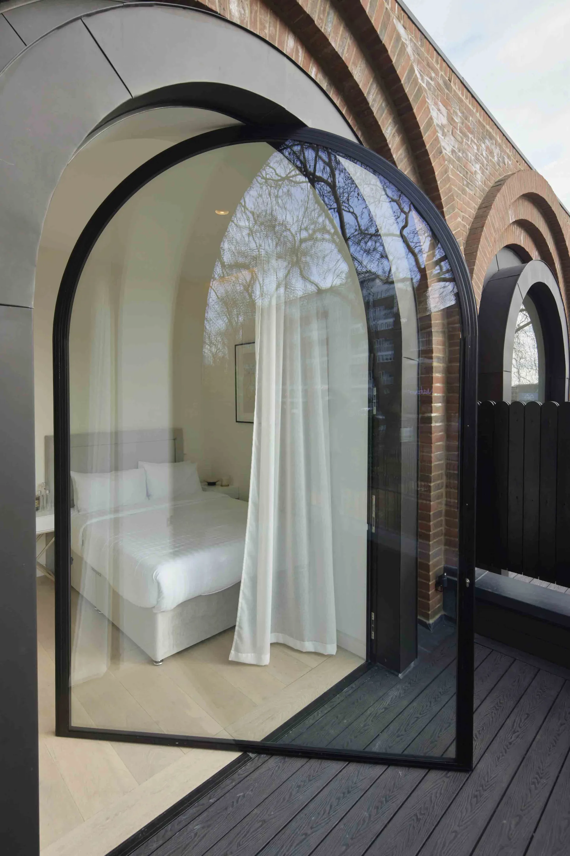 Modern architectural design featuring glass, brick, and wooden materials.