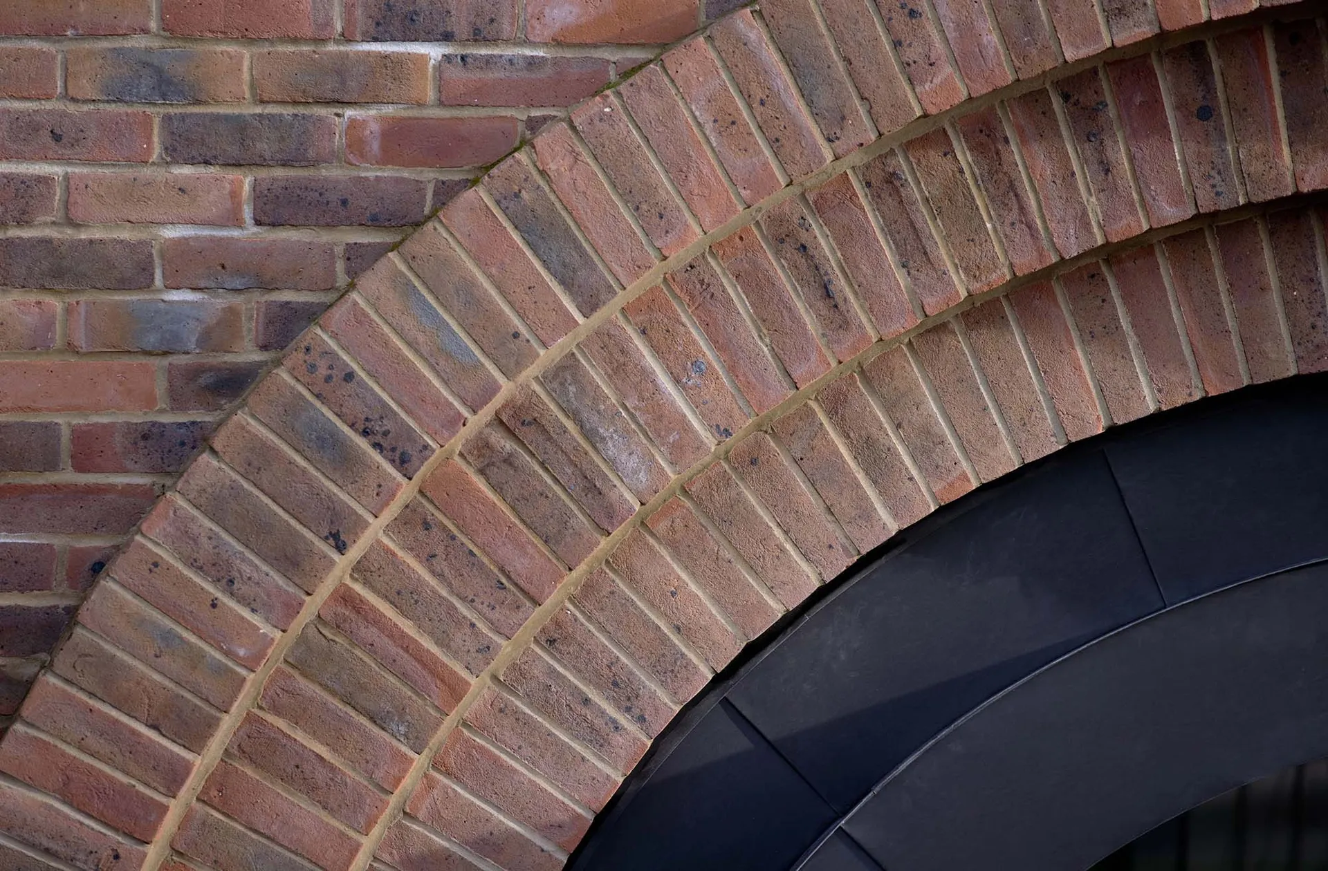 Detailed view of a brick outer building structure, showcasing architectural elements such as arches and materials.