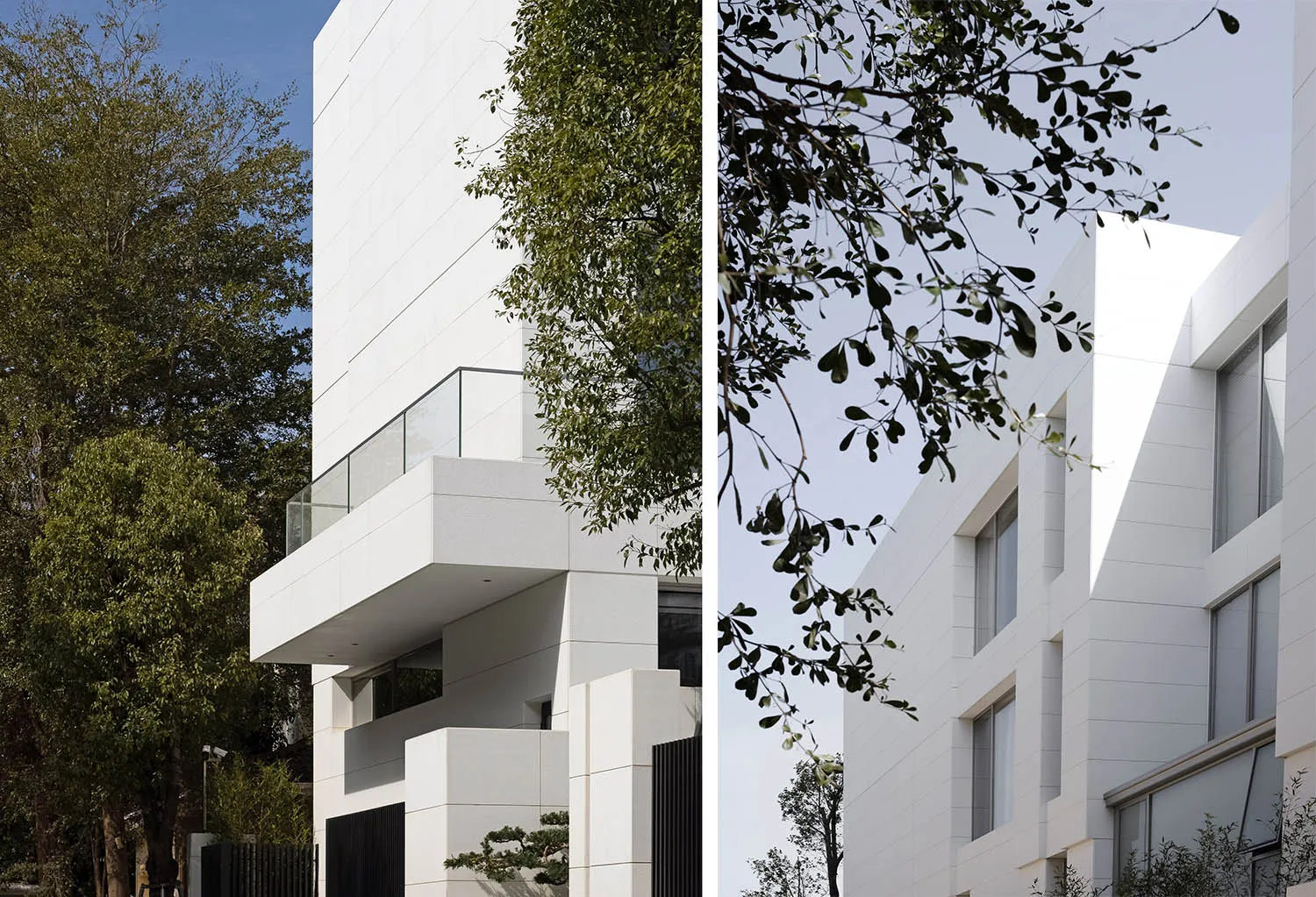 Contemporary residential building with white stone and glass exterior.
