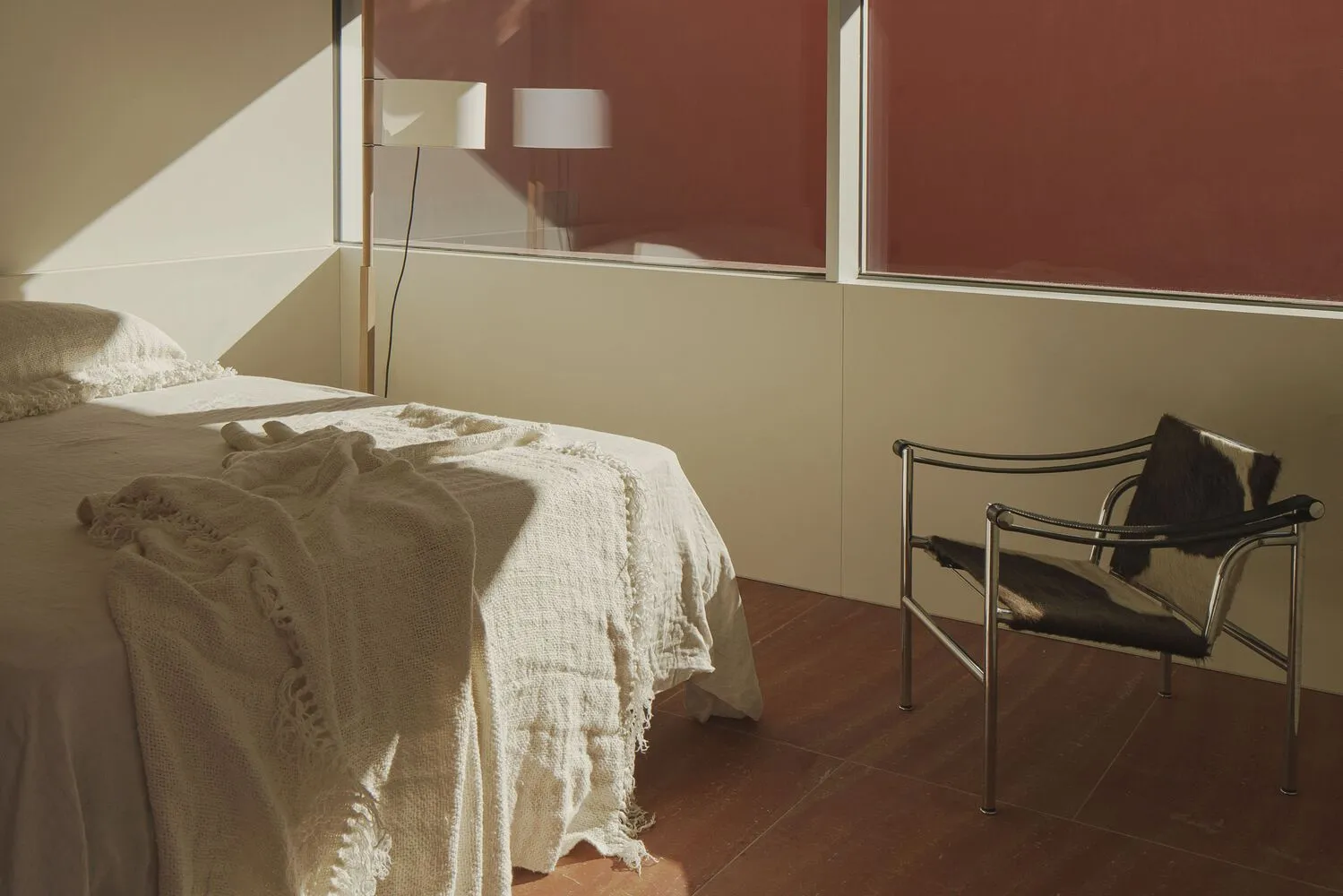 Minimalist bedroom featuring a comfortable bed with a textured blanket.