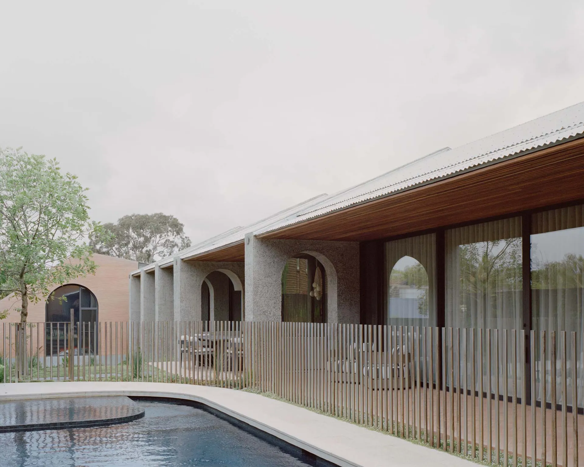 A modern house with a swimming pool and a concrete exterior.