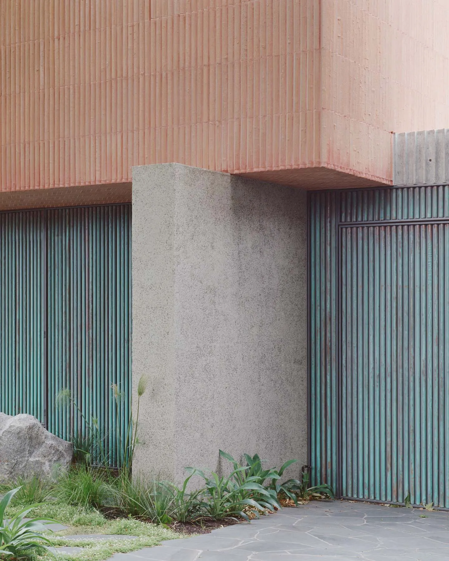 Modern building exterior featuring concrete panels and metal railings.