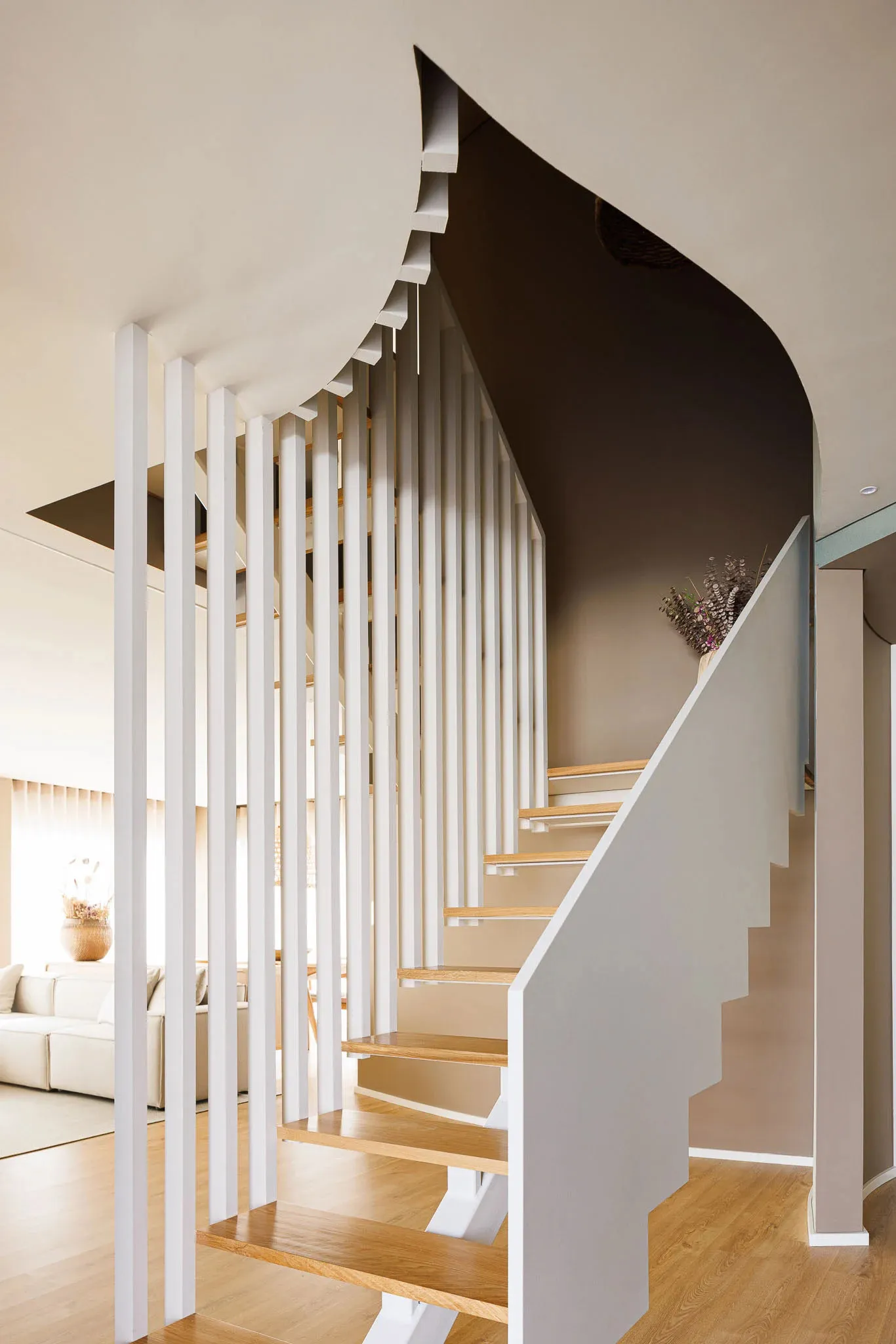 Modern staircase with wooden steps and metal railings in a well-lit interior setting.